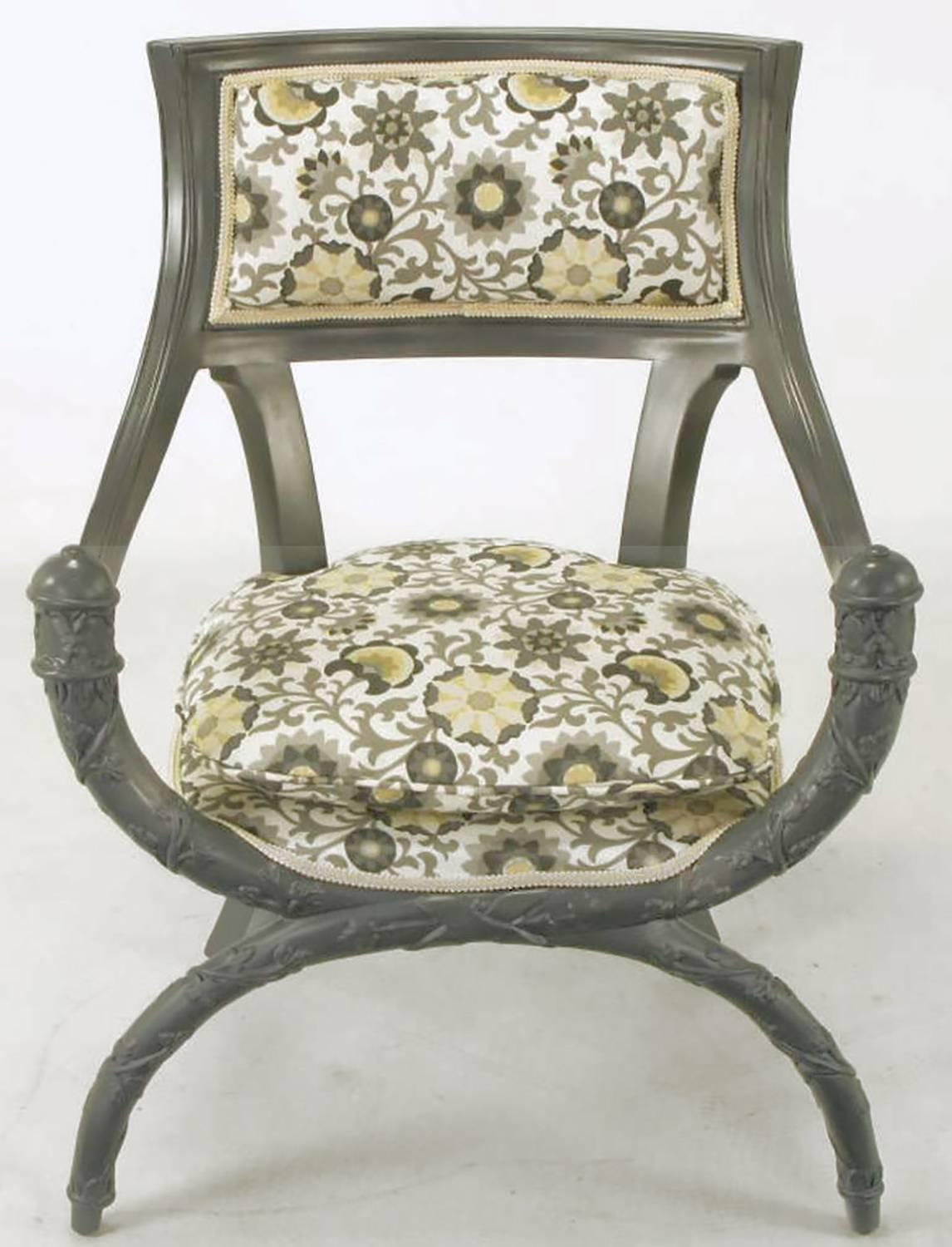 Paire de fauteuils Curule peu communs en laque gris ardoise sur bois. Les sièges et les dossiers sont tapissés d'un imprimé moderne gris et safran sur coton blanc. Les bras inclinés profonds et les pieds sabres arrière complètent le siège arrondi et
