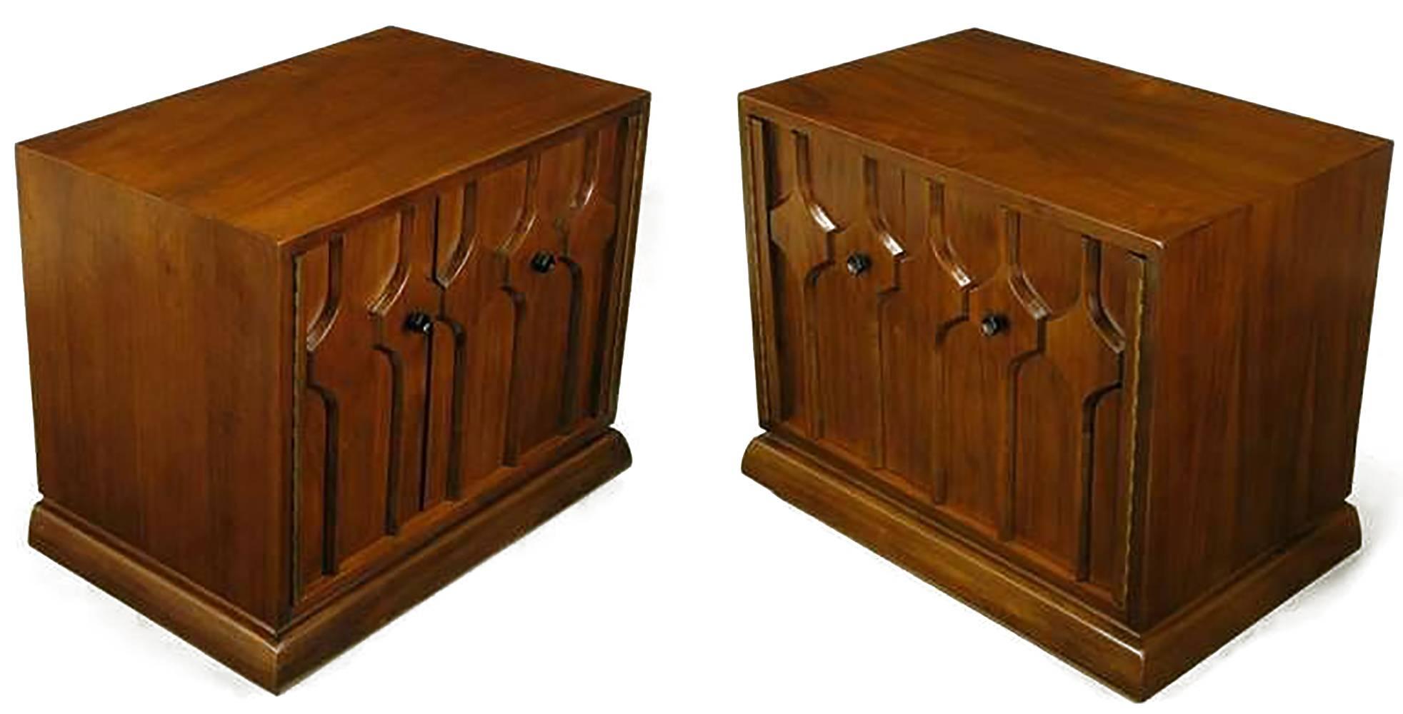 Pair of walnut two-door nightstands with carved hexagonal relief front doors. Two piano hinged doors open via black iron hexagonal pulls to reveal single shelf two-section interiors. Heavily built, with quality on par with Baker Furniture or