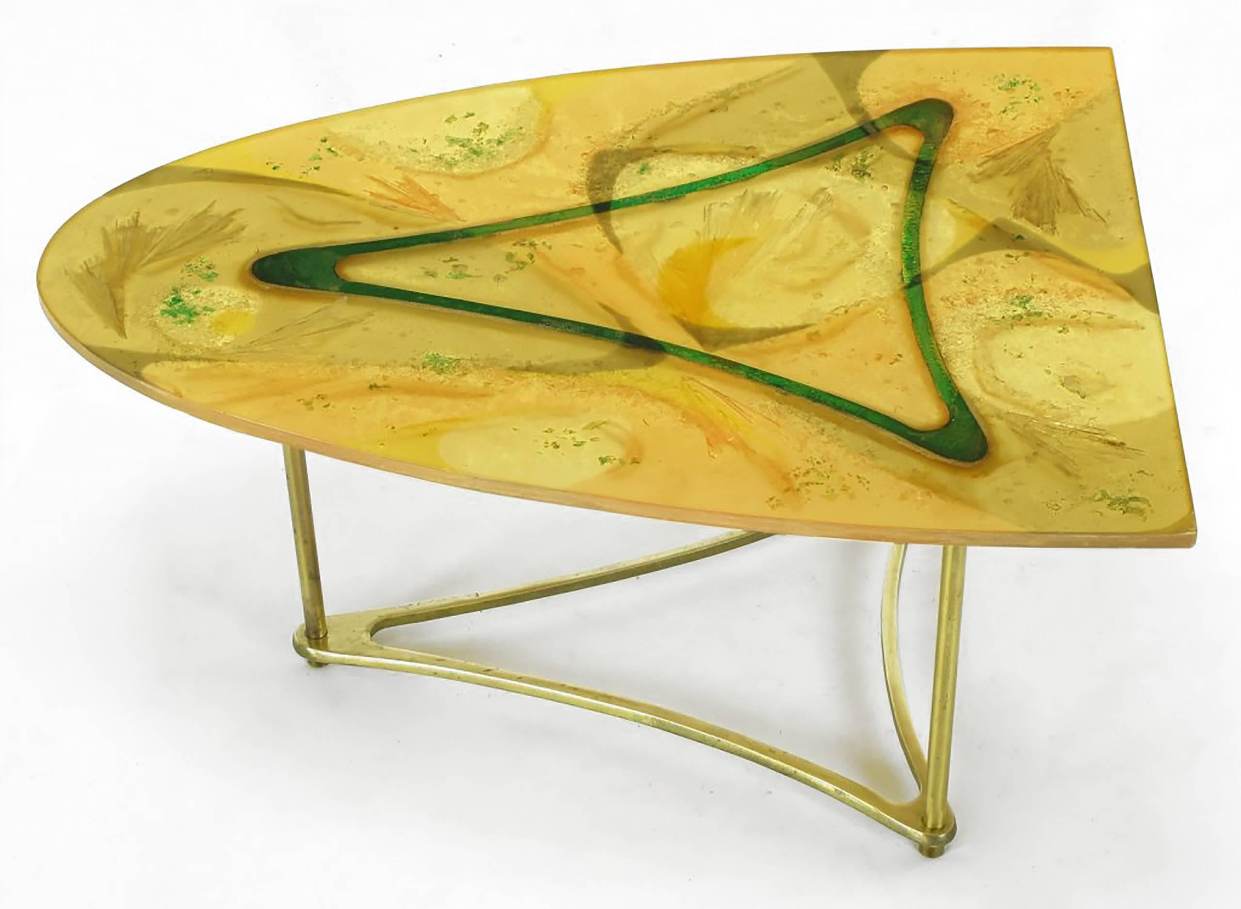 One third surf board shaped side table on triangular brass base. Three brass legs attach the triangular brass base to the abstract designed umber, gold and green semi opaque resin top. One of a kind artist designed coffee table. Looks to be of