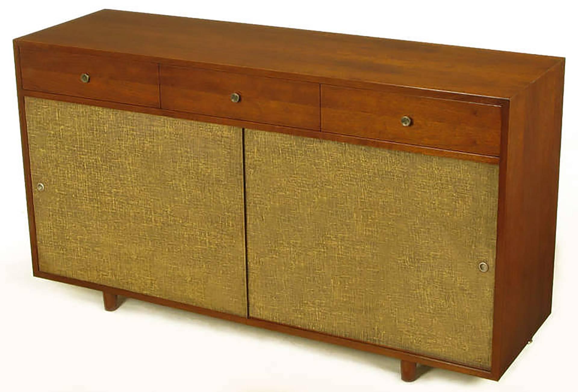 Beautifully restored to original condition, nine-drawer dresser or cabinet, with sliding linen wrapped doors. Three exposed drawers with nickel pulls and six more birch front drawers behind a pair of sliding linen covered doors. Looks to be a custom