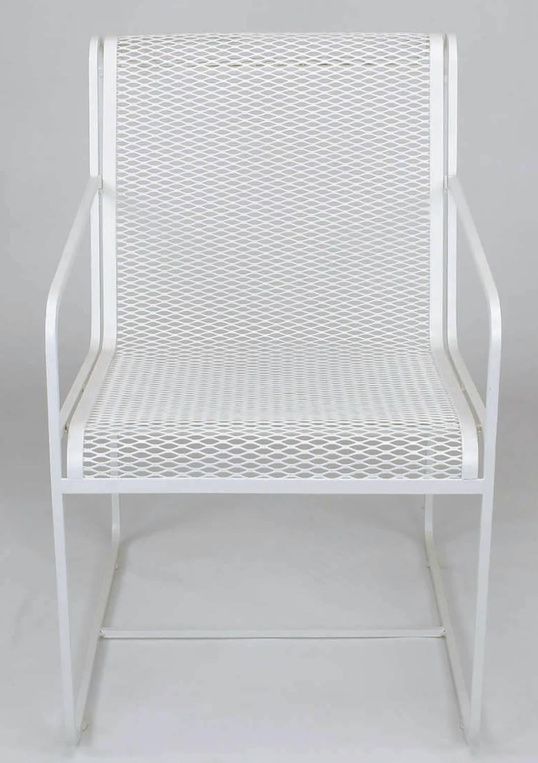 Rare set of four Maurizio Tempestini for Salterini white lacquer over wrought iron framed and iron mesh outdoor dining chairs. Minimalist design with open arms and linear form, iron mesh seat and back flow seamlessly.