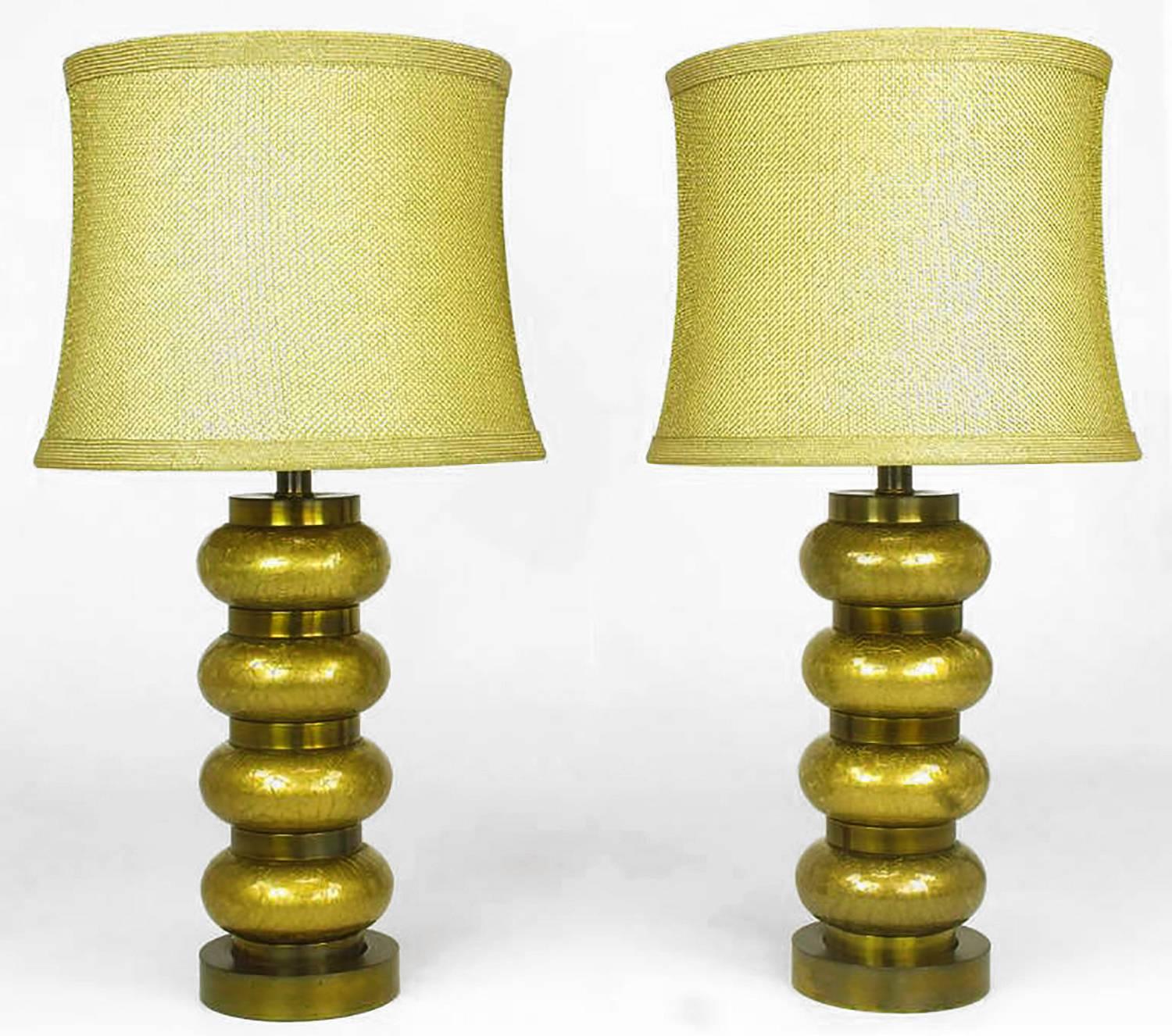 Pair of reverse gilt and brass table lamps by Paul Hanson Co. Inc. circa 1950s. Alternating bands of gilt crackle glass ovals and patinated brass rings combine for sculptural form. Original extra large milk glass diffusers and gold fishnet shades.