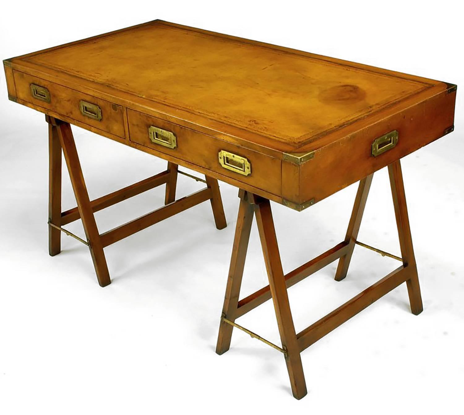 Original early 1900s campaign desk with tooled leather top. Desk has two drawers with double brass recessed pulls and brass caps on every corner. Double 
