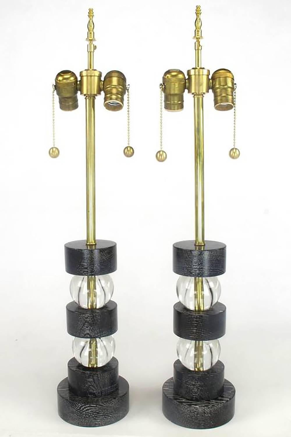 Excellent pair of black lacquered and cerused oak crystal ball segmented table lamps with brass double sockets. Great size for nightstands or at either end of a console table. Restored with new brass stems, double socket clusters and rewired. Sold