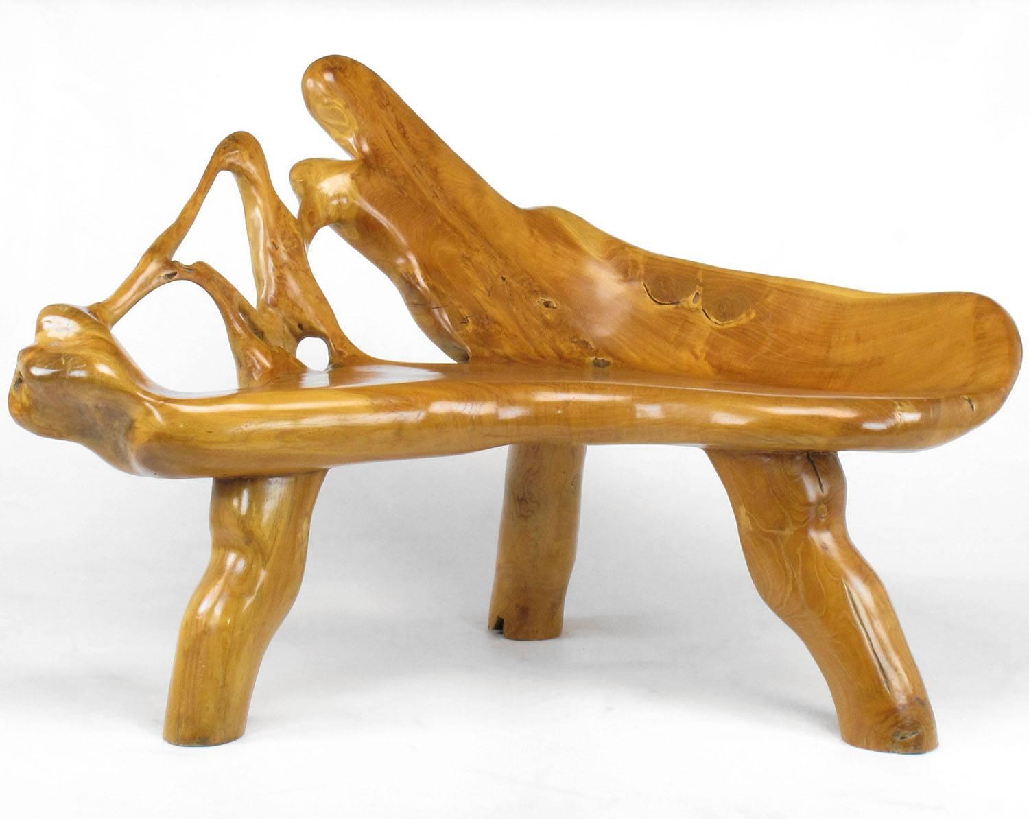 Excellent organic form teak three-leg root bench in the shape of a boomerang. Finished in a medium gloss that brings out all the beautiful wood grain. Perfect for a corner space or as a stand alone bench. Versatile piece that can work in a modern as
