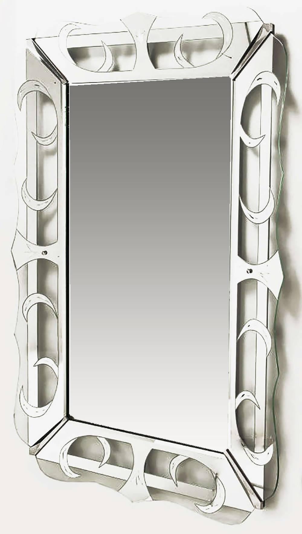Very large Art Deco Mirror framed in glass which has been wheel cut etched and silver patterned in crescents and open trapezoids. Scalloped edge glass frame with metal bracketed corners. Mounted on a black lacquered wood backing.
Can be hung