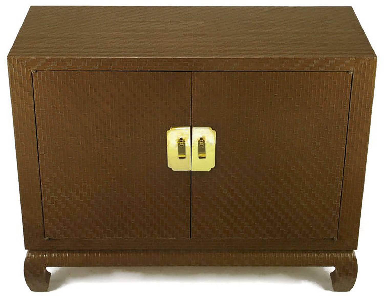 Baker Asian modern cabinet in chocolate lacquered Grassclotha chocolate brown lacquered grasscloth cabinet from Baker's Far East collection. Ming style turned legs and large brass escutcheons backing solid brass drop pulls. The lacquered grass cloth