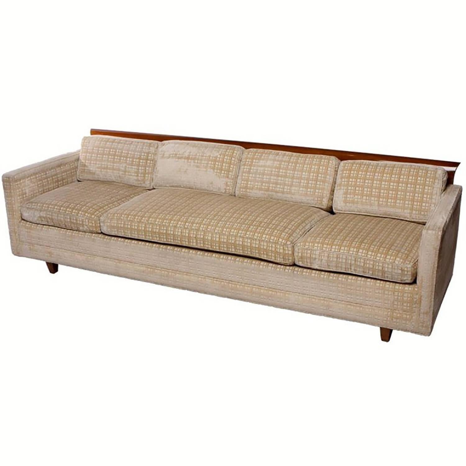 Tuxedo sofa with architecturally curved walnut wood across the top back. Walnut legs and creamy beige crosshatch cut velvet upholstery over down cushions. The light areas on the upholstery is the direction of the NAP and not a defect. The upholstery