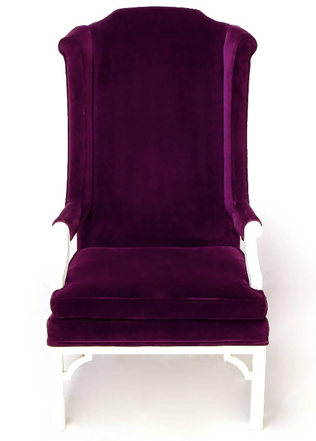 Plum velvet upholstered neo-Chippendale wing chair from Erwin-Lambeth. White satin lacquered frame with open arms. Carved front legs with quatrefoil and elongated oval insets, open corner brackets and saber style back legs.