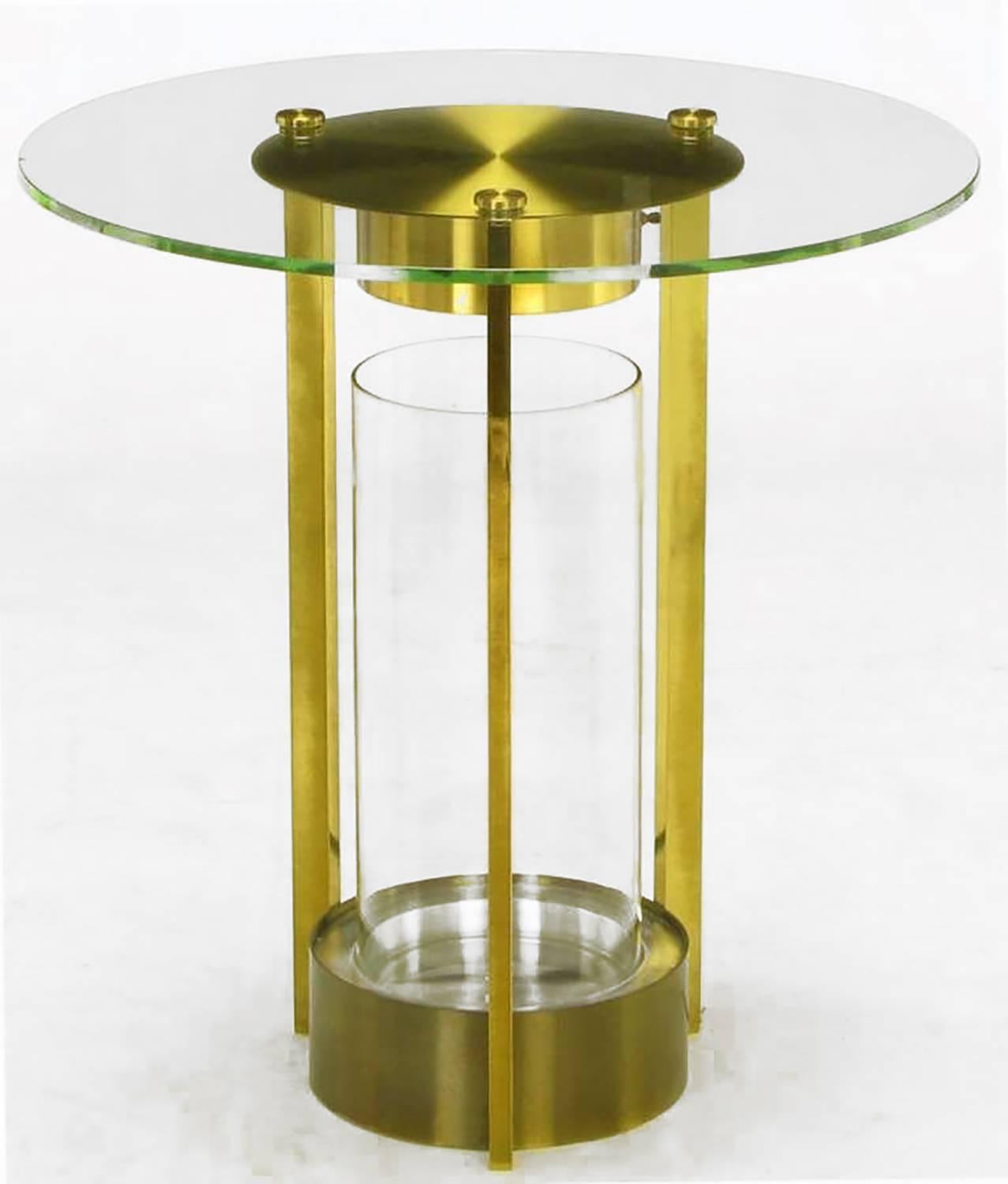 Unusual, yet very elegant, glass and brass end table with three legs, center glass cylinder terrarium and lighting element. One-half inch thick glass top is secured in three points with solid brass discs. Often attributed to Dorothy Thorpe.