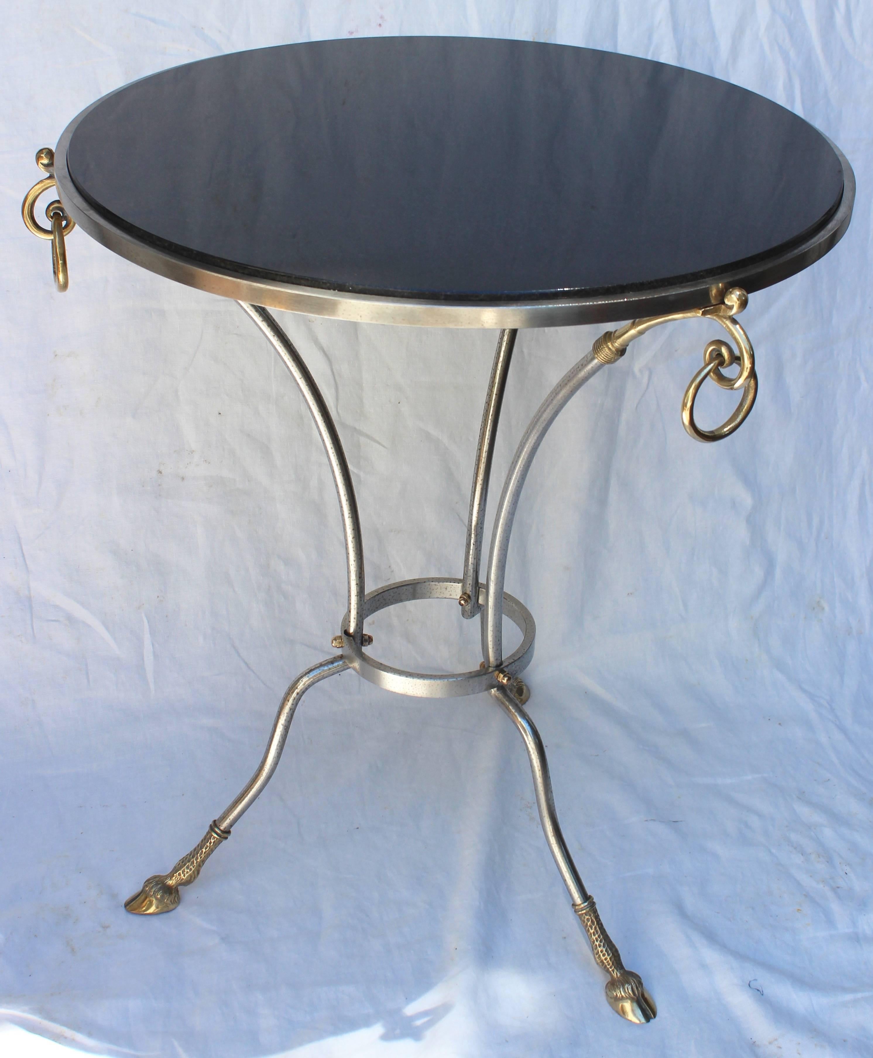 Jansen style round table. Black granite top with metal and brass base and brass rings.

tabletop measures 23.5