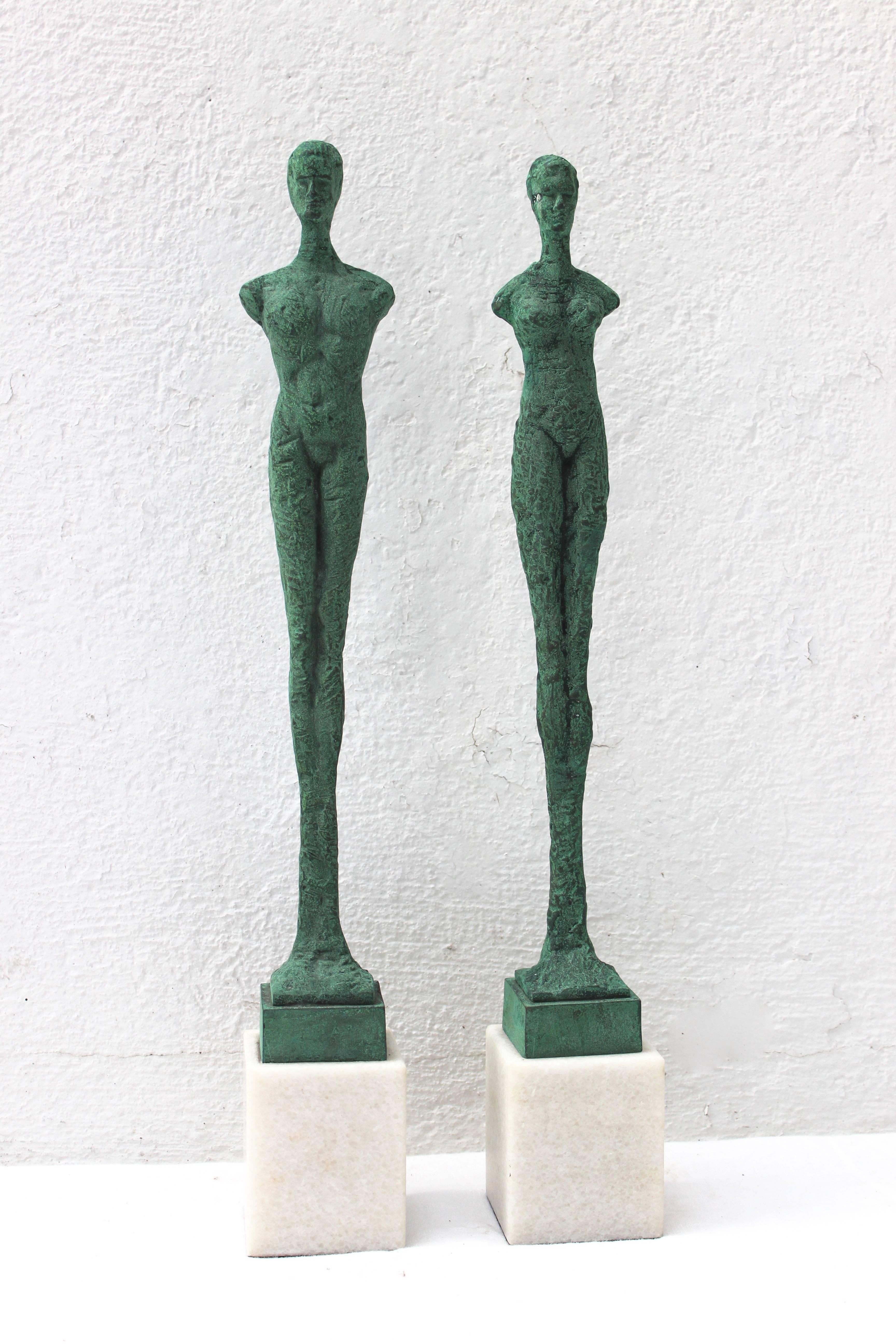 Wonderful pair of patinated bronze Giacometti style figures mounted on marble block plinths.

Male figure measures 20.75