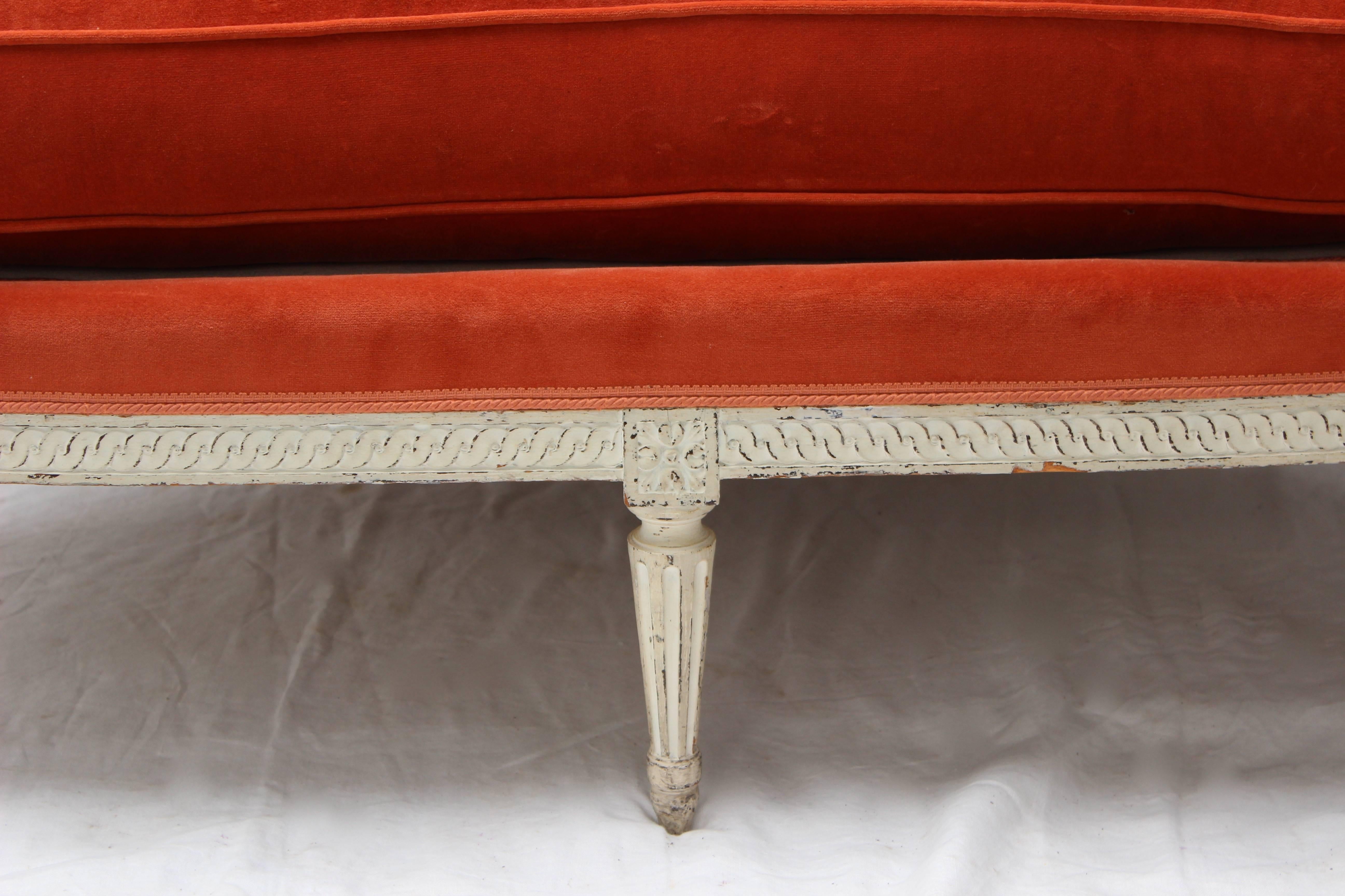 Newly upholstered Jansen carved and painted off-white settee.