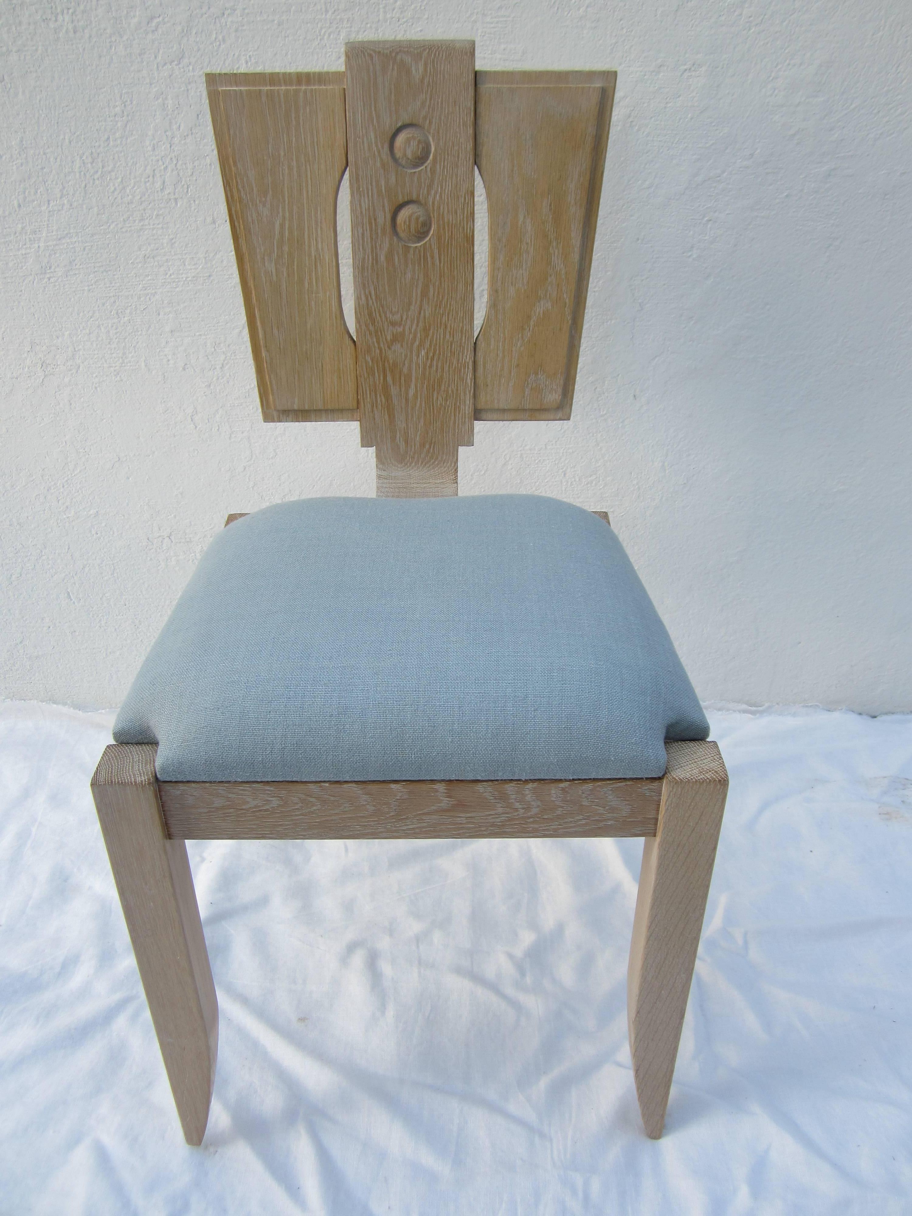 Set of four limed oak chairs in the style of Charles Dudouyt blue linen seat.