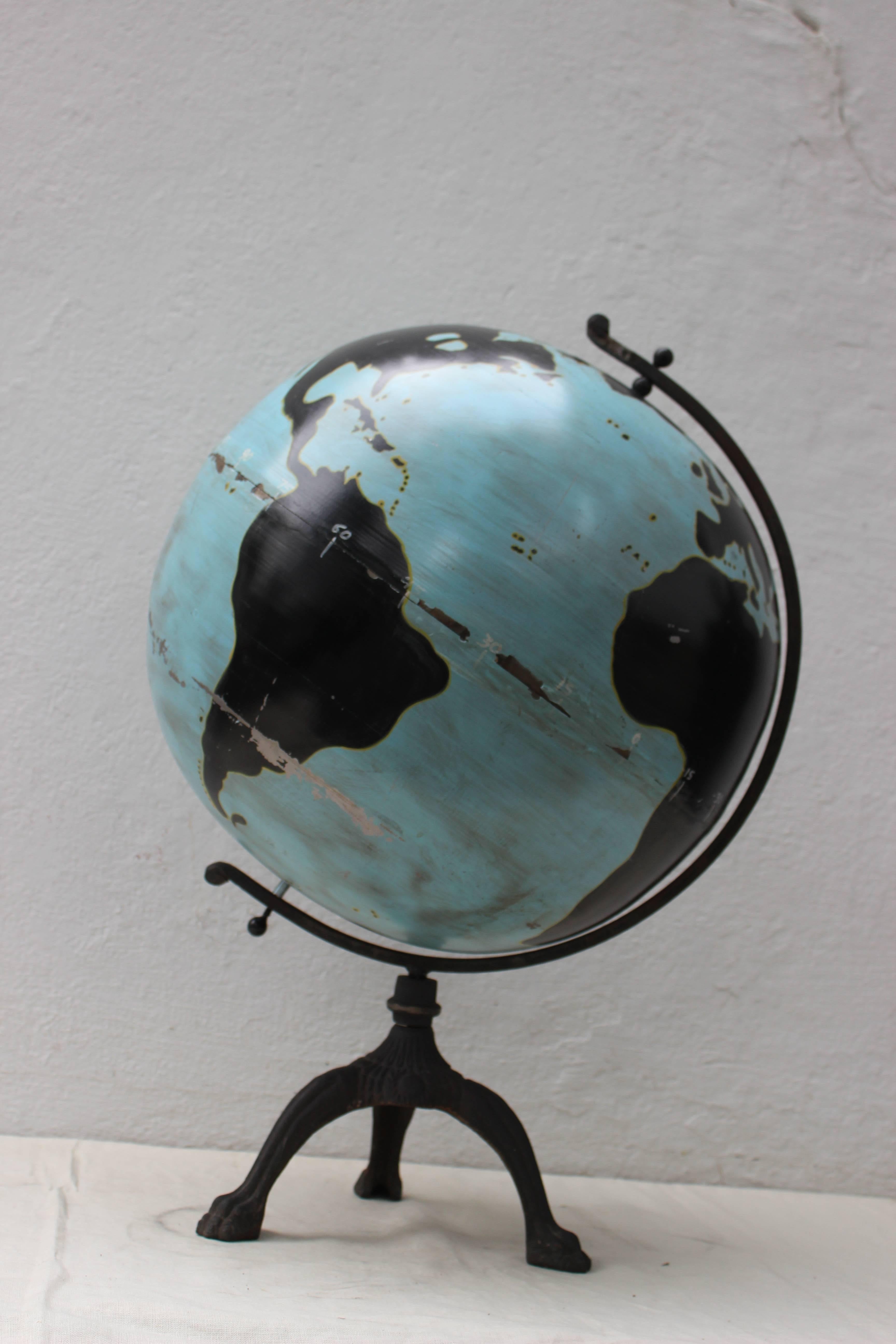 Wonderful and unusual painted metal globe of great scale... blue with black continents on an iron base. Minor paint chips and bent in the bottom area of the globe.