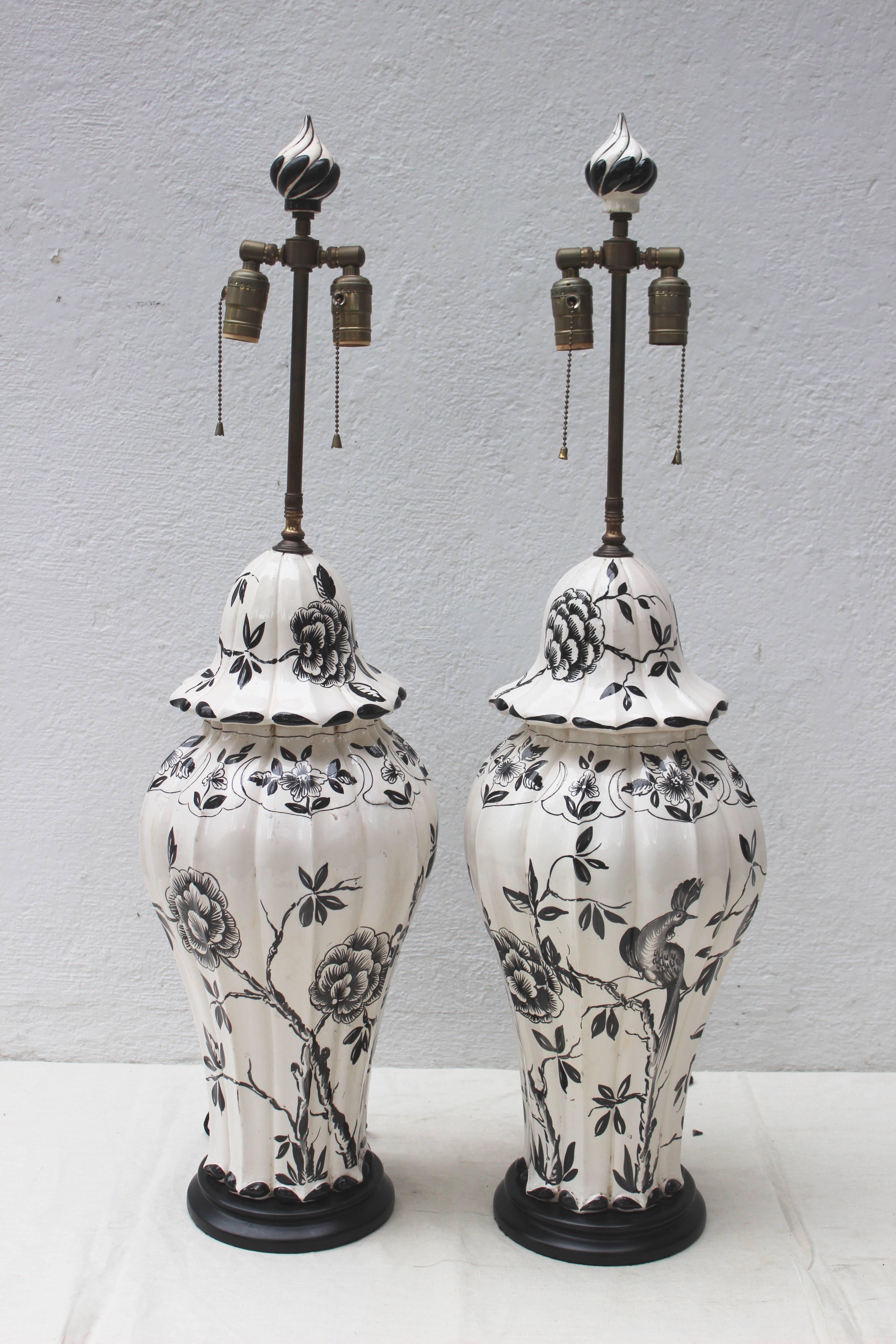 Great pair of black and white ceramic lamps of great scale with matching finials and newly wired with silk cording.