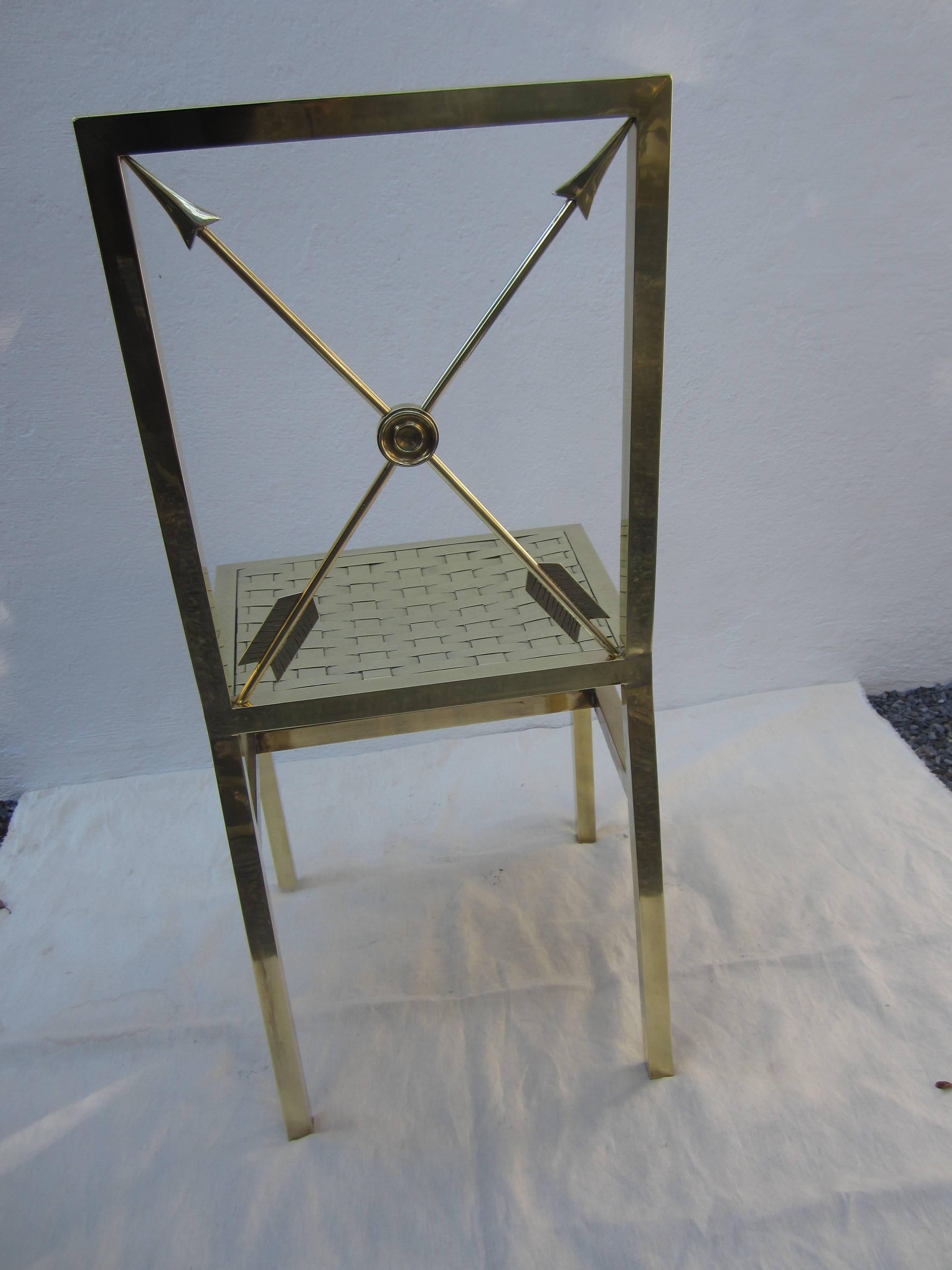 Jansen style brass chair with woven brass seat and arrow back in the Campaign style.