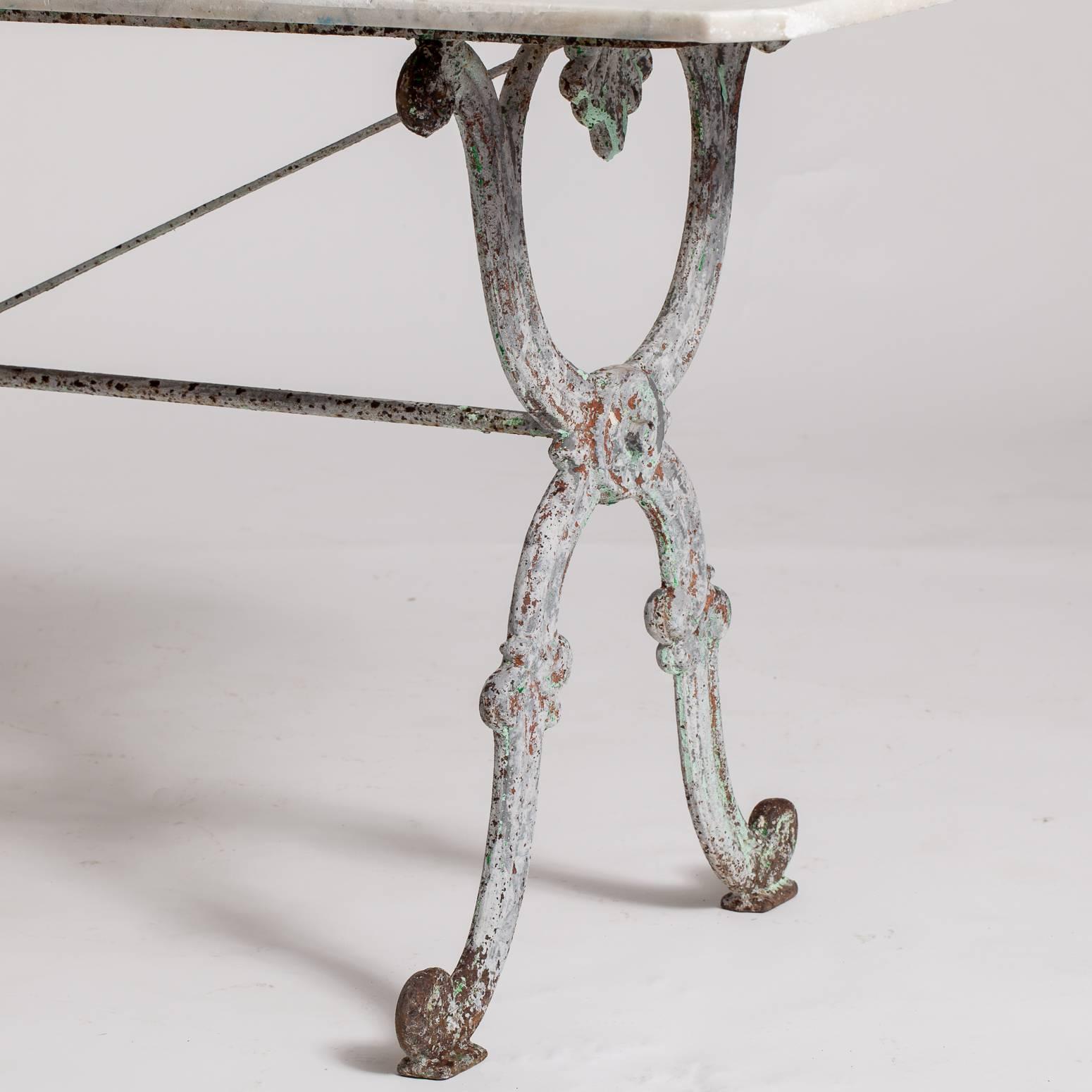 This beautifully proportioned table has a cast iron base with a central medallion and traces of the original green paint remaining. The marble top with unusual squared off corners has a great patina and is in good condition.

$5,900.
Measures:
