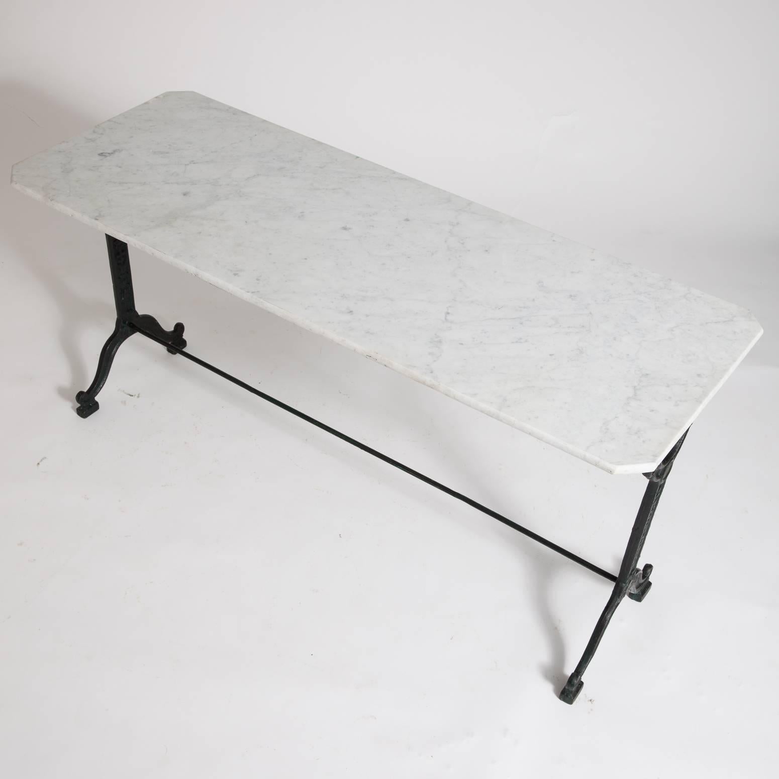 The cast iron base of this table has a central rod for stability and is painted a very dark rich green. It is marked Fenouil Hennon, metal-workers of Nimes France.

Measures: 58” long,
22” wide,
28” high.