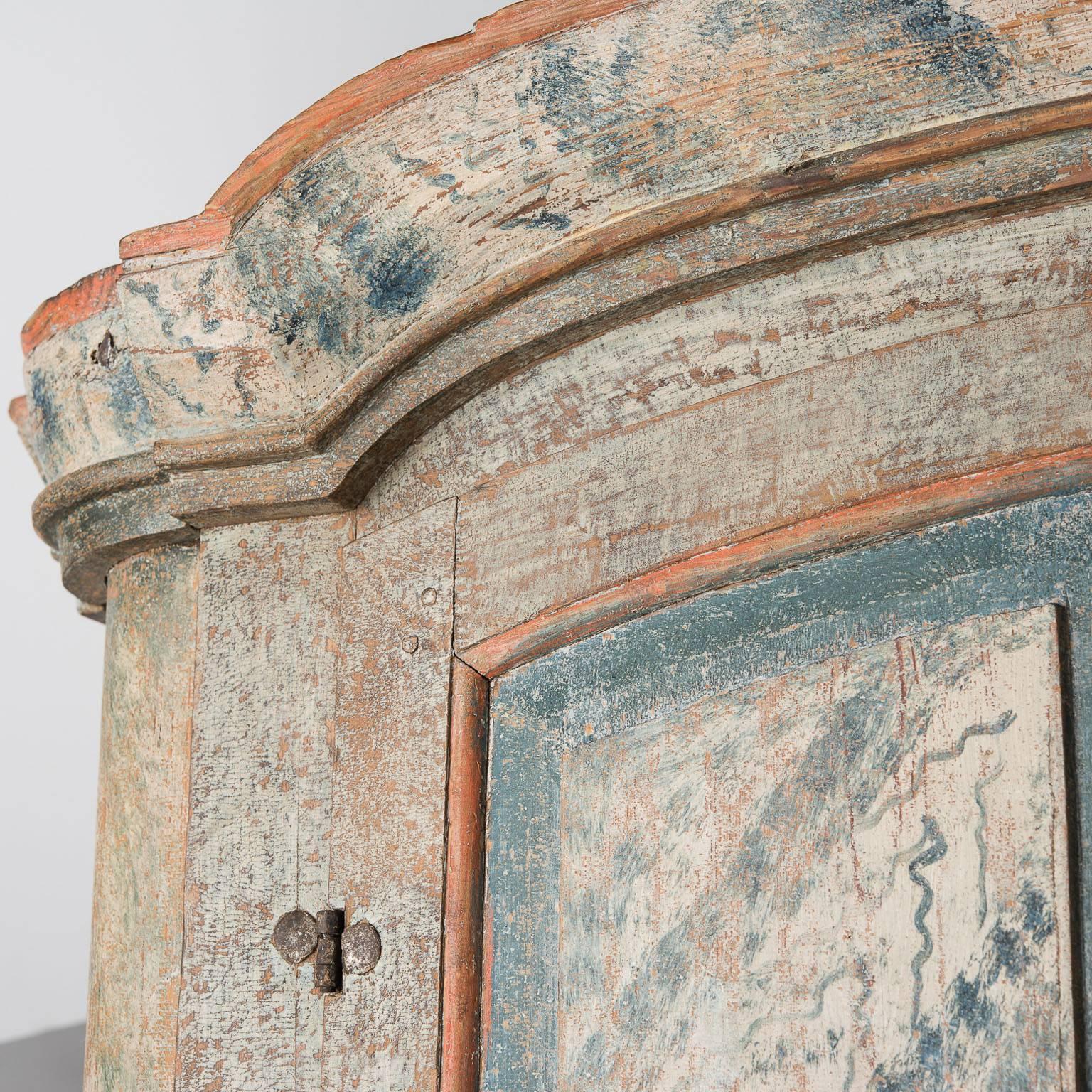 This cupboard, from an area northwest of Stockholm, was made by a master craftsman and artist. The combination of faux grain painting in blue and coral on the doors is fantastic and all original. This special piece has all the best elements of the