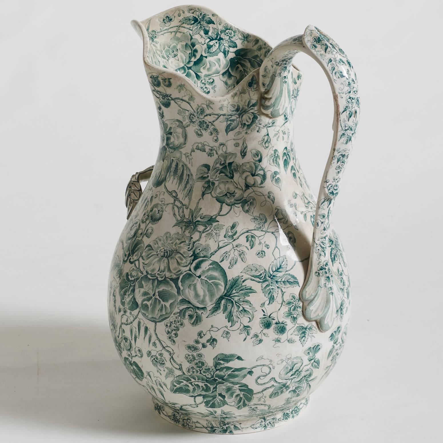 This lovely floral pitcher of an impressive size has an extra handle in the front to aid in pouring water. The piece has beautiful details of flowers and leaves on both handles. It is marked Creil et Montereau, a fine maker of porcelain in the 19th