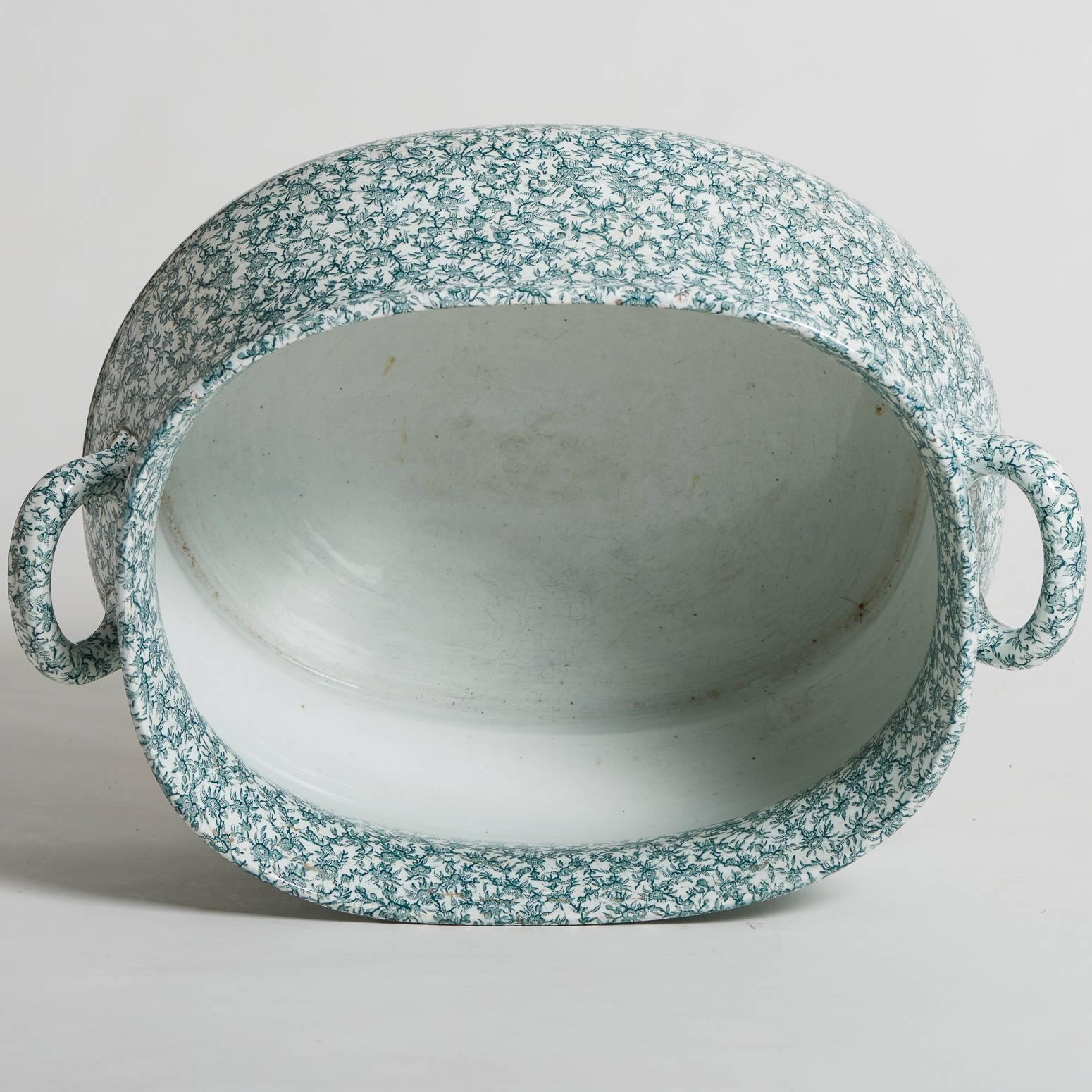 This Ironstone footub with a curved oval shape and two handles has a charming pattern of green flowers against a white background. It has the important mark of Creil and Montereau, Fine maker of porcelain and pottery in the 19th century.

Measure: