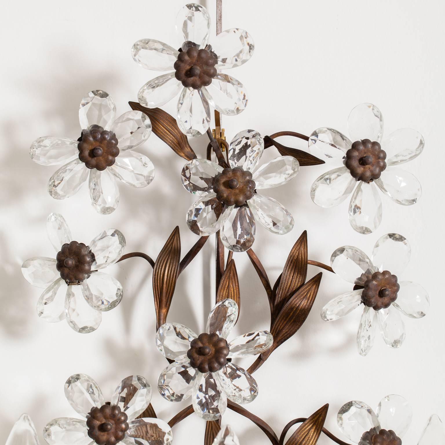 This pair of French crystal flower and brass sconces date from the early 20th century. The flower crystals sit in three tiers and are surrounded by brass leaves in perfect proportion. Each sconce has three lights, newly electrified.

Measures: 22