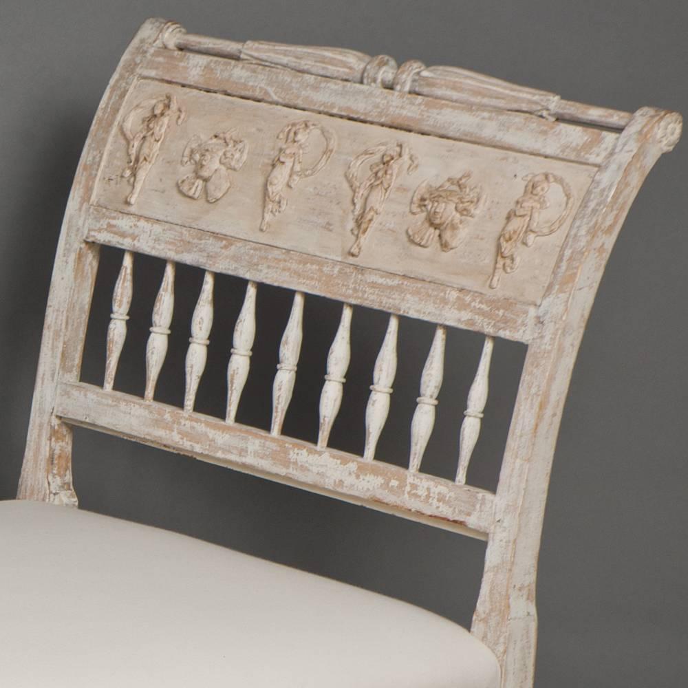 This lovely bench from Lindome, Sweden has been dry scraped to the original surface with touches of pale paint remaining. It has classical carvings on both ends and is stamped with the mark of maker Johannes Andersson, (1763-1840), a well know