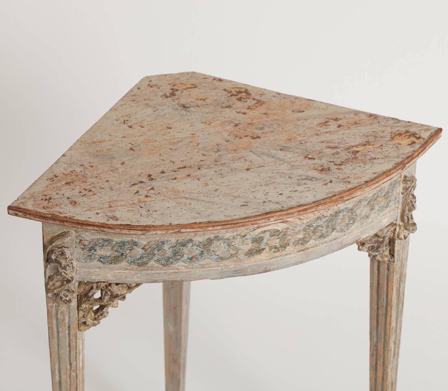 This charming table from the late 18th century retains traces of the original paint and faux marble painted top. The elegant apron has scroll details and applied ornamental carvings at each corner with traces of gilt, ending in reeded legs.