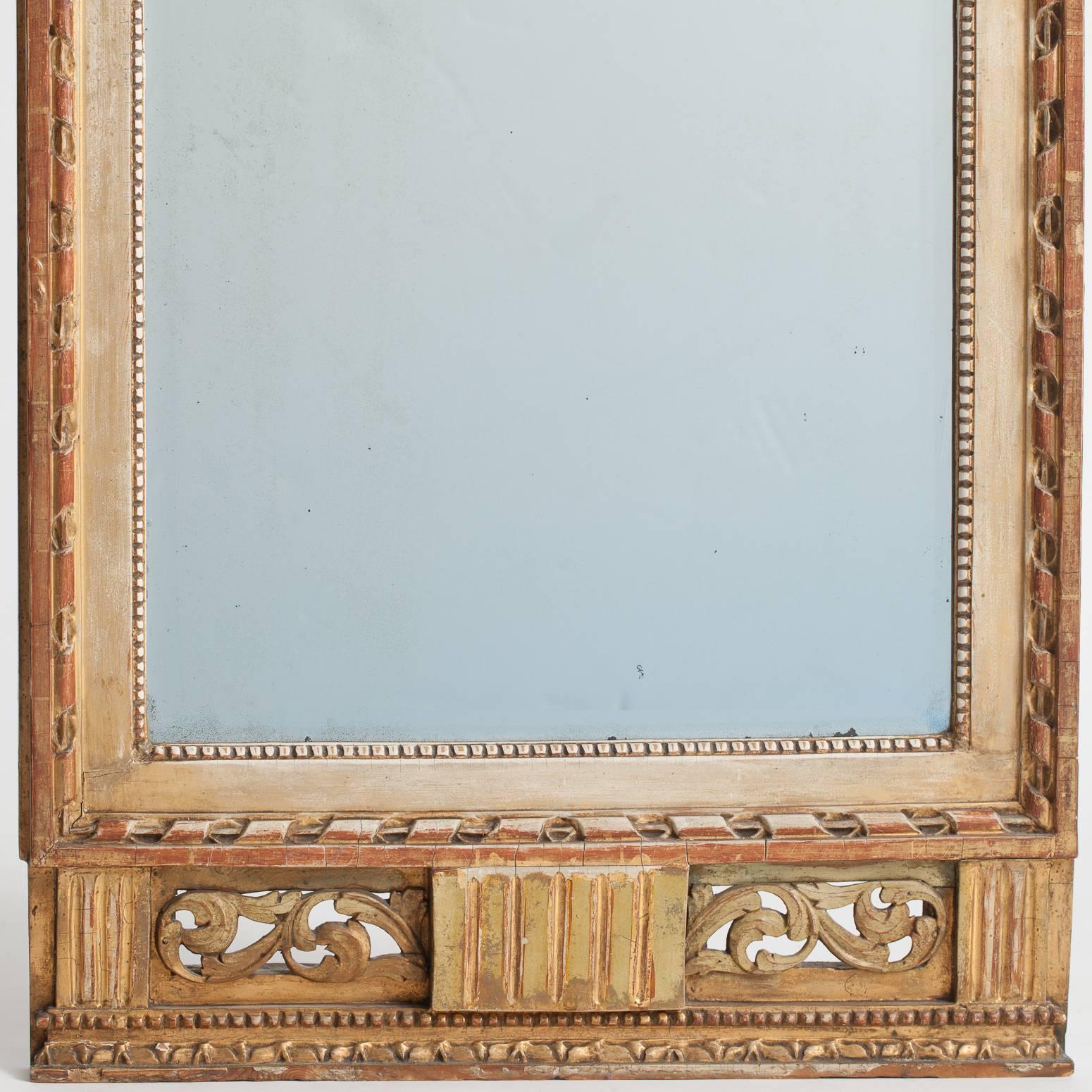 This elegant mirror was made in Stockholm, circa 1780 and bears the official stamp of the Stockholm mirror guild as well as the personal stamp of the maker and certified gilder, Lago Lunden (1744-1819). The mirror has a lovely gilded bow and