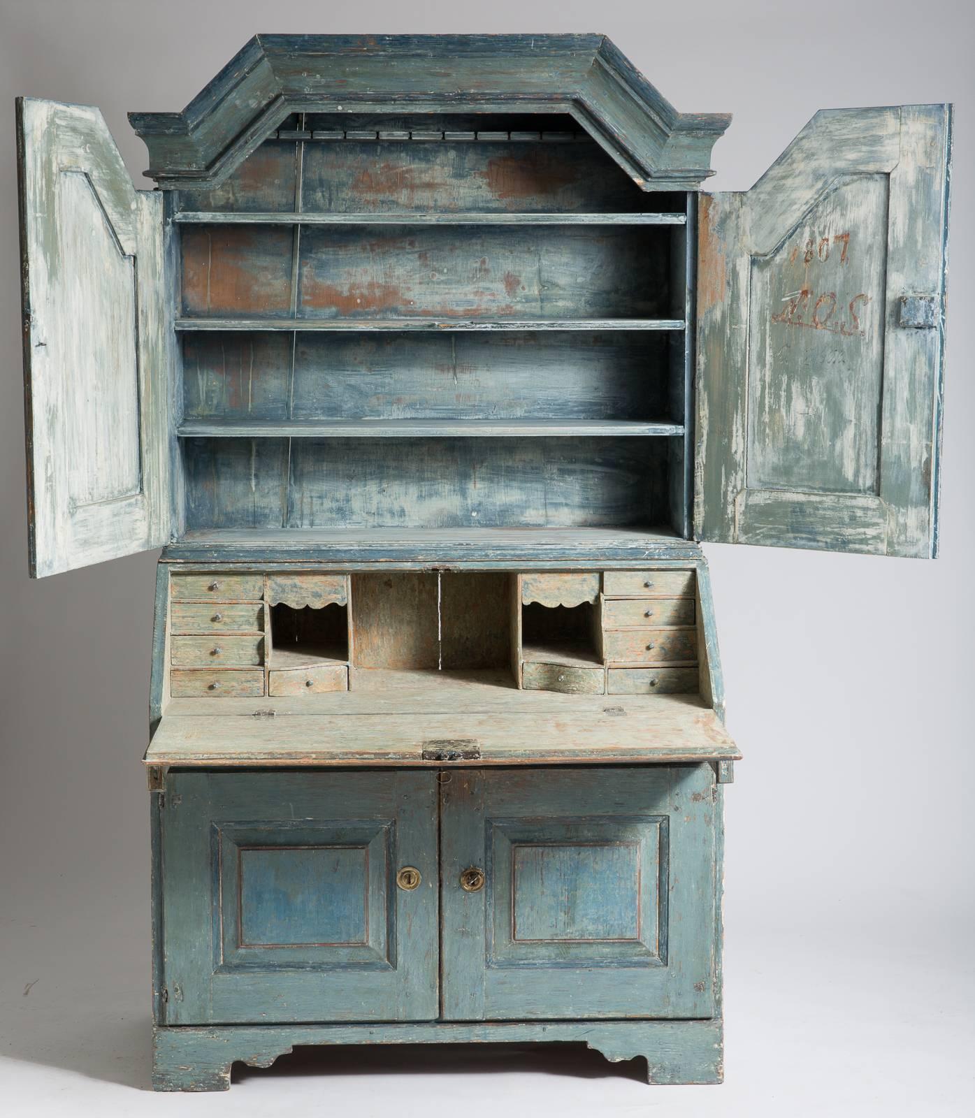 This beautiful slant front secretary is unusual because it is completely original with spectacular blue paint inside and out and the original locks and hardware. It is signed by the maker and dated 1807. The interior of the desk has eight small