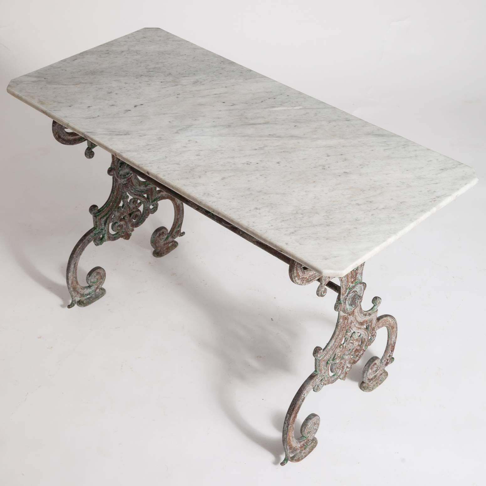 This table from the Napoleon III period has a very elaborate scrolled base that shows traces of old red and green paint and an old marble top in great condition with squared off corners.