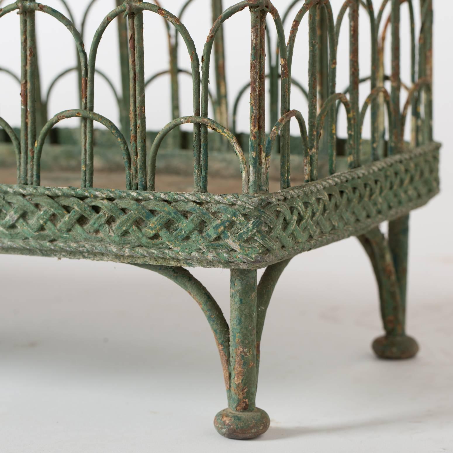 These freestanding jardinieres date to the mid-19th century and retain just the right traces of the original green paint. The wirework is in perfect conditions as are the liners. They stand on elegant pad feet and are a great pair to add charm and