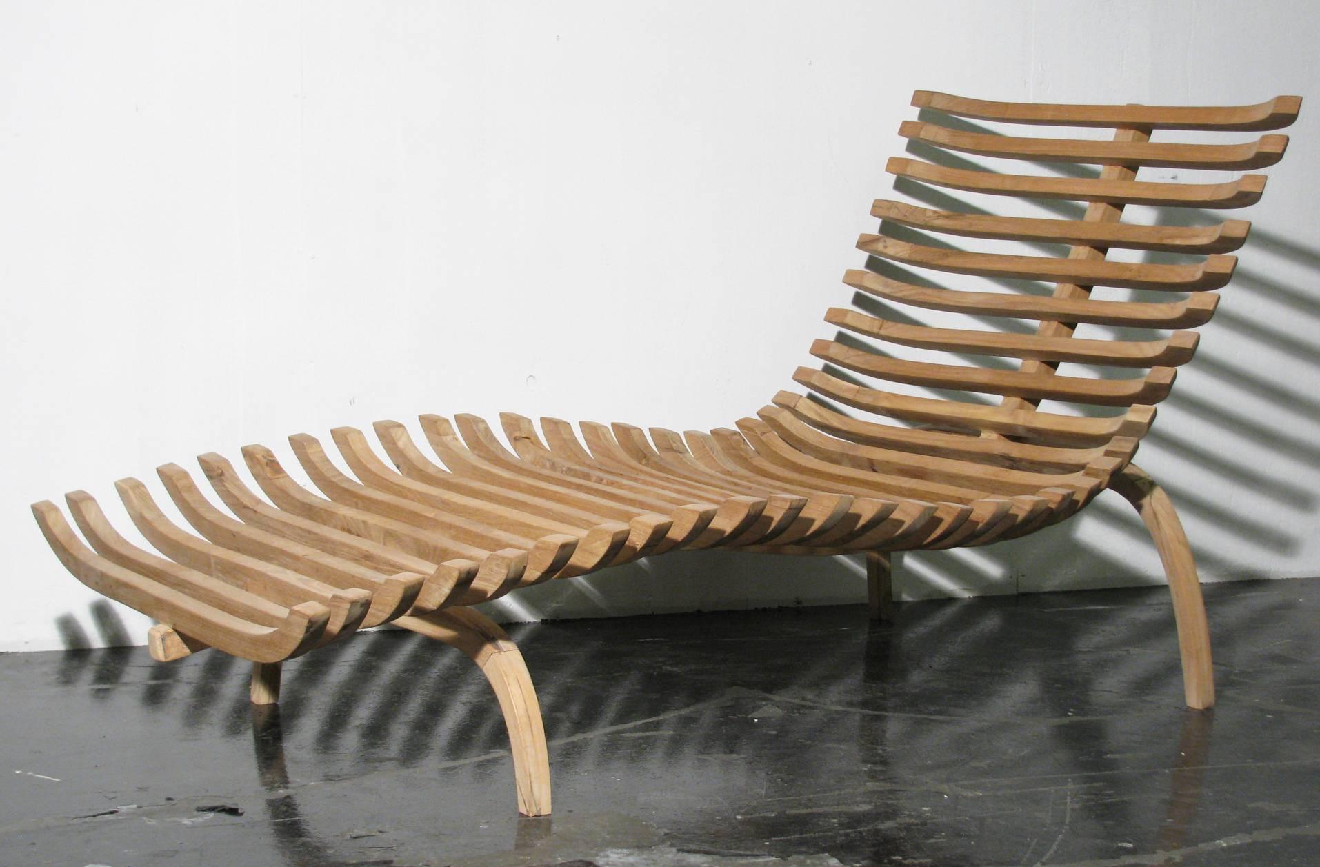 Sculptural chaise longue constructed of solid teakwood with steel core reinforcement on all bands and frame base. Natural wax finish. Pure and organic form.