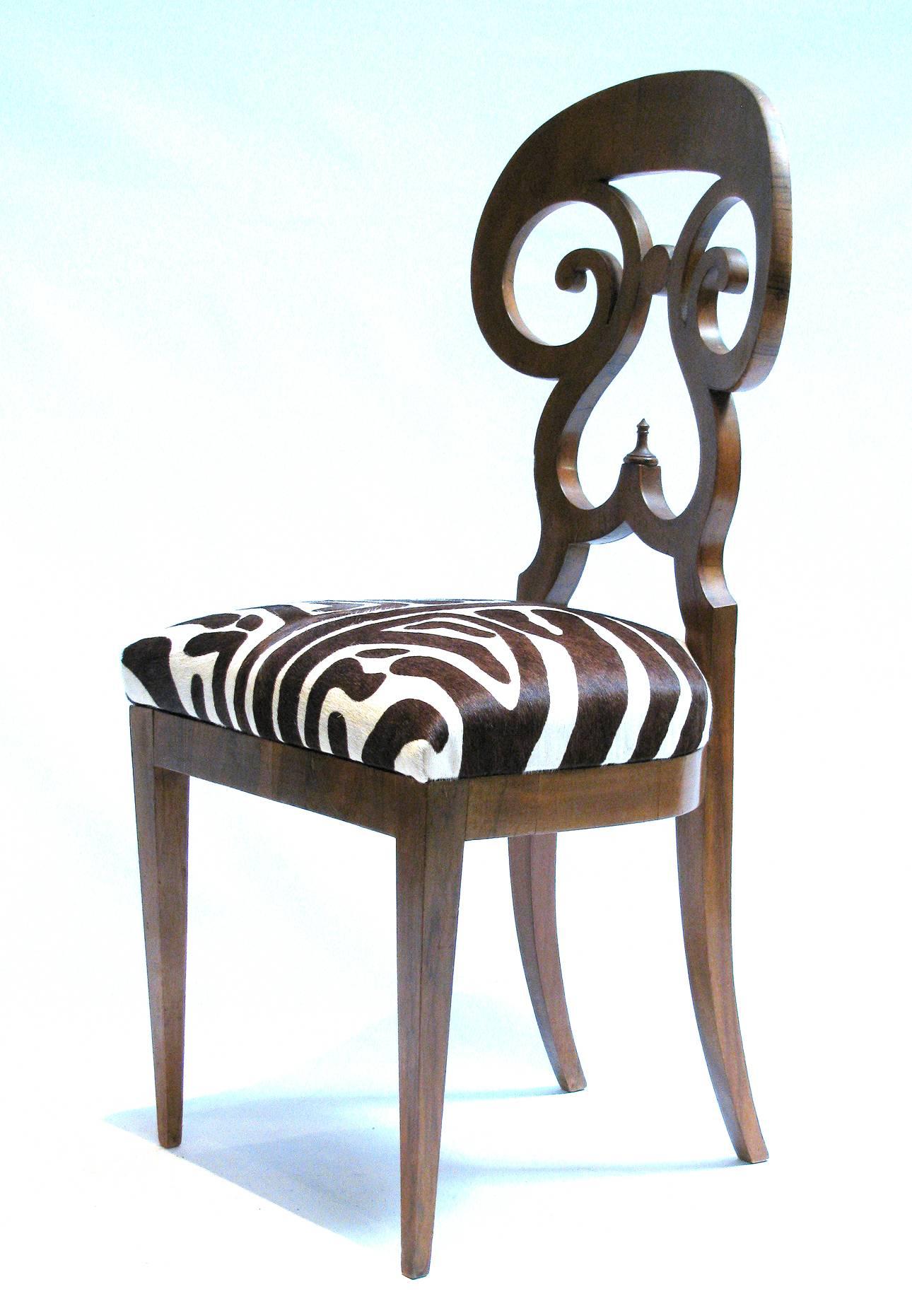 Italian Biedermeier double scroll side chair

Heavy walnut veneered wood with zebra print hair hide seat. 

An example of this chair is featured on page number 215, 