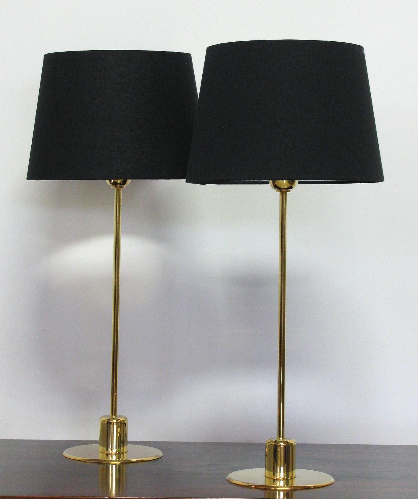 Modernist style polished bronze table lamps designed by The Mirak Collection. Each comprised of a thin bronze stem and round disk base. Imported from Paris, France. Dimensions as shown: 21.5 H (with shade) 17 H (to top of socket) 5.5 inch diameter