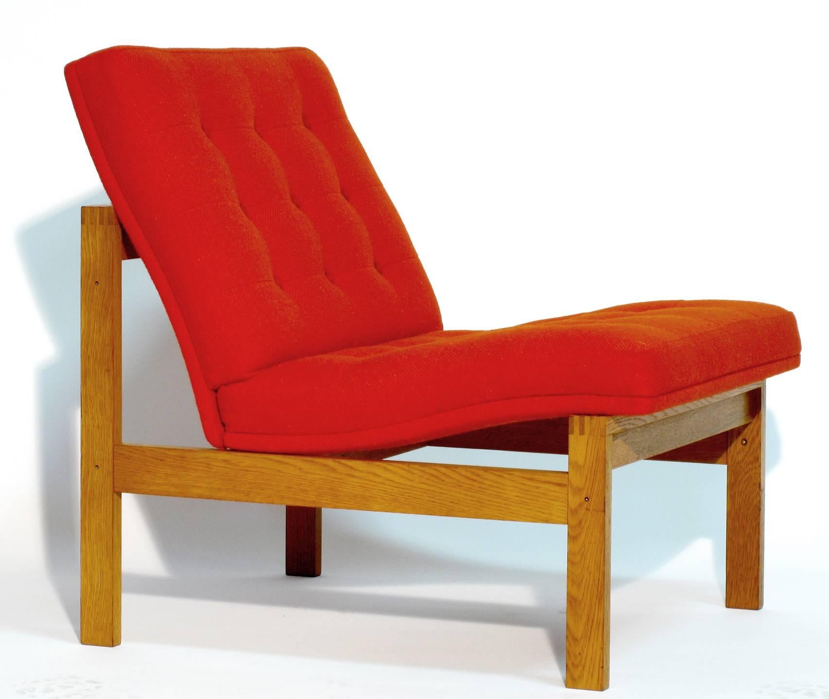 A pair of Danish modular easy chairs designed by Torben Lind and Ole Gjerløv-Knudsen, for France and Son. Oakwood with original buttoned orange wool tweed upholstery in excellent condition. Seat cushions were removed from the frame and