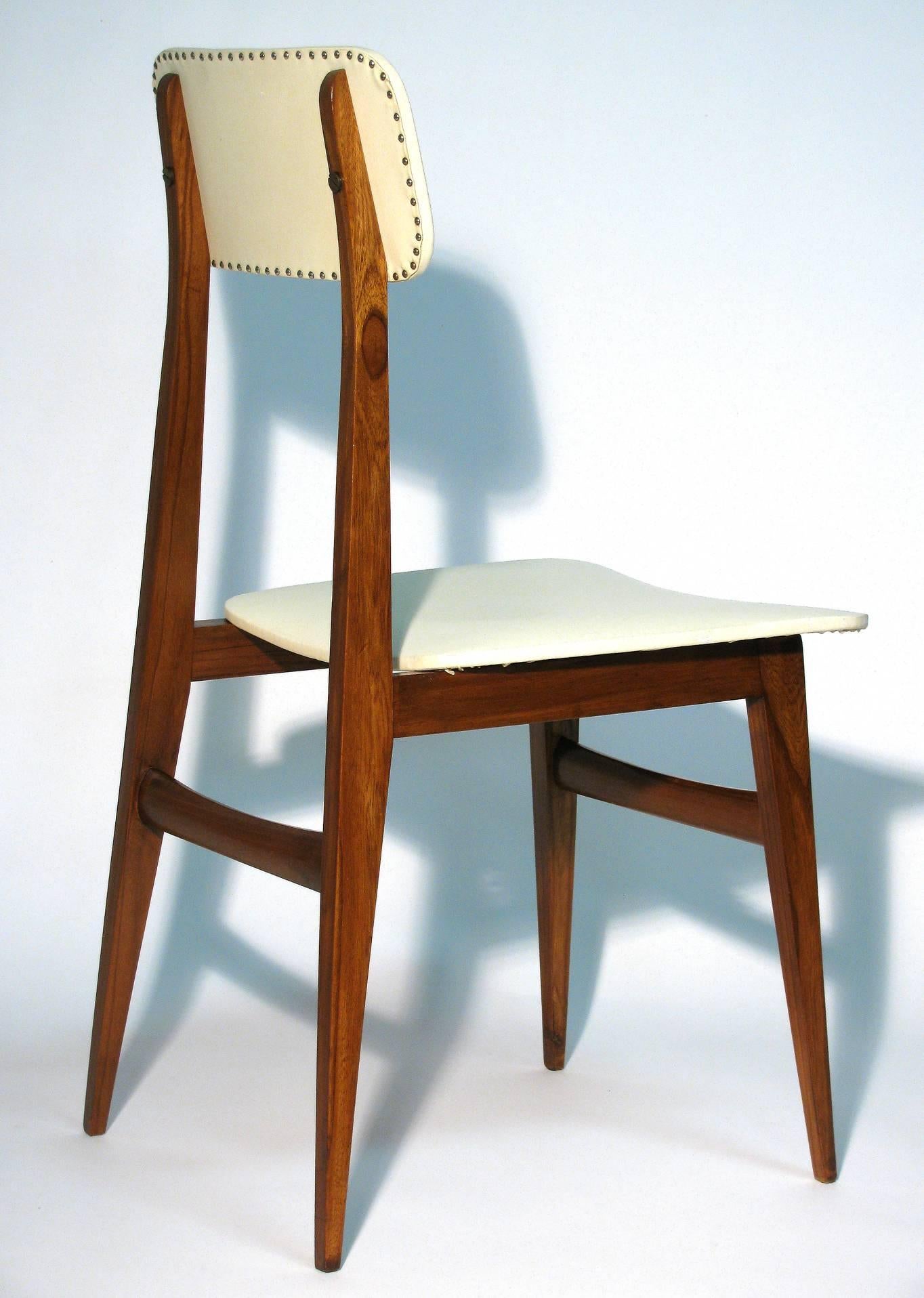 Italian modernist design side chair, in the manner of Gio Ponti, of walnut with original Lorica upholstery. The backrest features two large brass flat screws with nailhead trim along the edge.