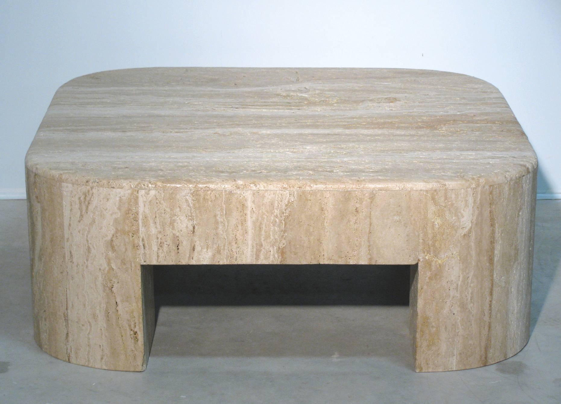 Monumental travertine cocktail or coffee table of natural travertine stone. Square in form with rounded corners. We love the unpolished 