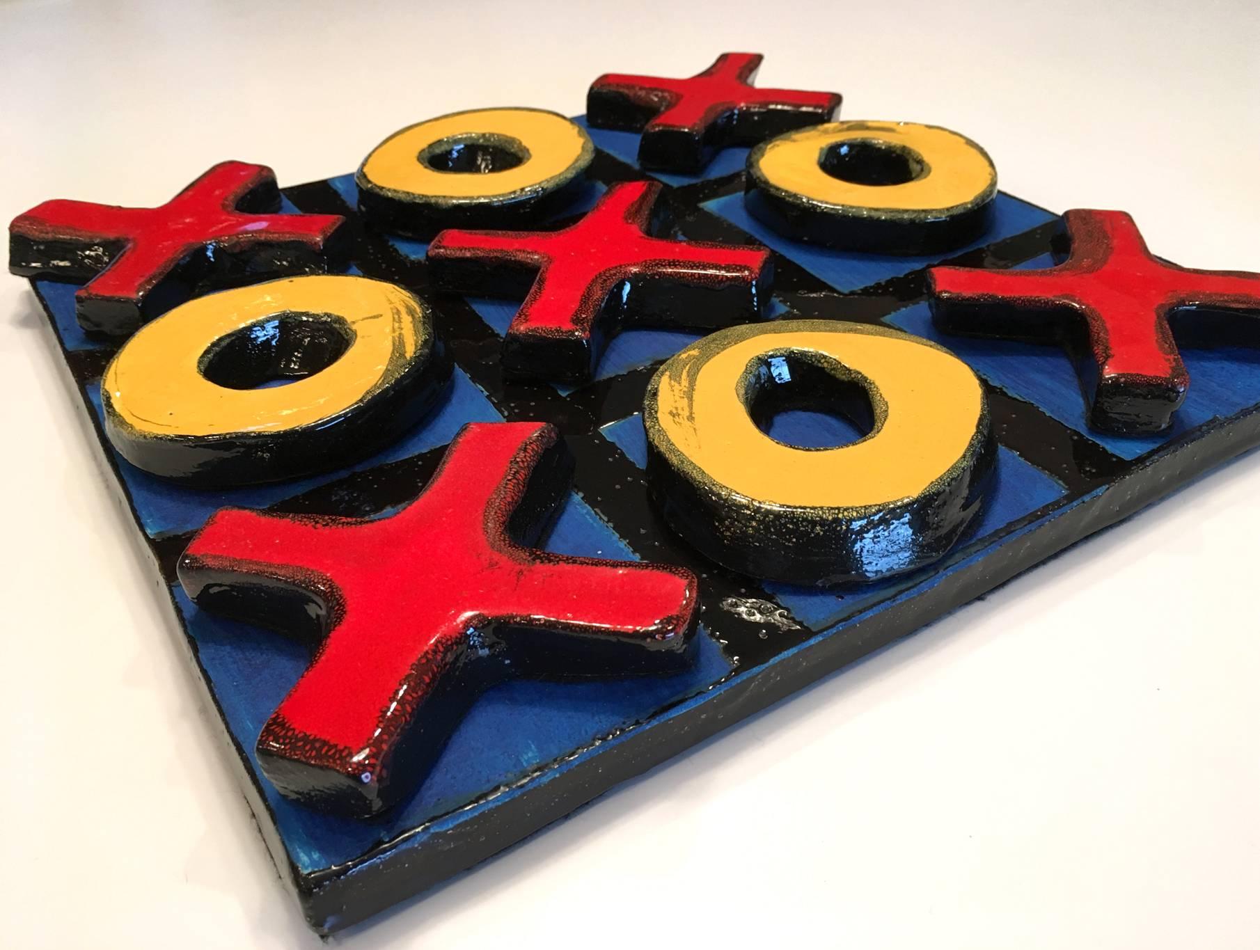American school glazed ceramic sculpture of a tic tack toe, 20th century, unsigned. Five X's and five O's lined with felt bases, rest loosely on a square base, all glazed and fired ceramic.