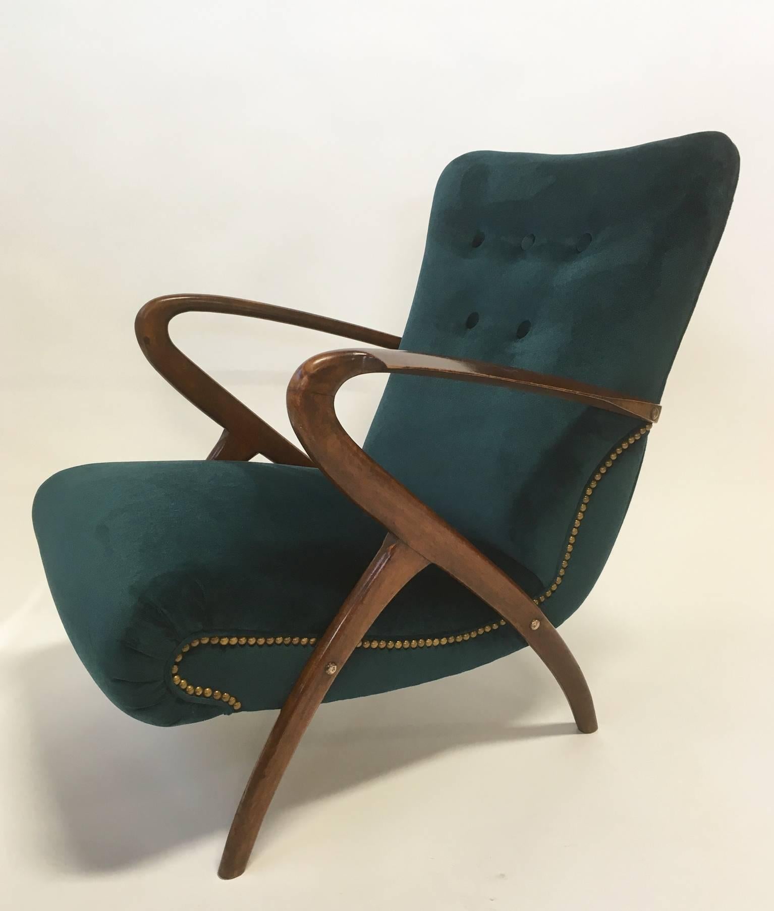 Sculptural open-arm lounge chair in the style of Paolo Buffa, Italy, circa 1950, of polished walnut frame, with custom velvet upholstery in a deep turquoise color. Brass nail trim accents the lines along the sides, and curves along back.