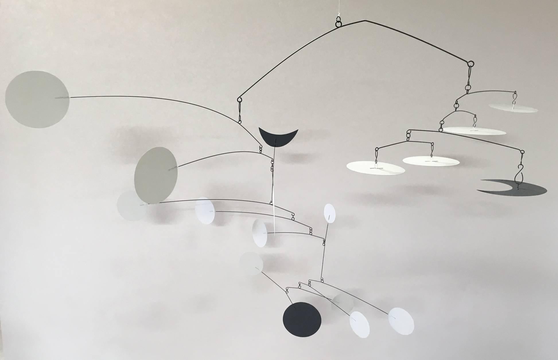 A very large Kinetic mobile designed by a California artist, who remains anonymous, with inspiration from Alexander Calder. This massive Kinetic mobile is comprised of metal wire and thin metal circular and crescent paddles; powder-coated white and