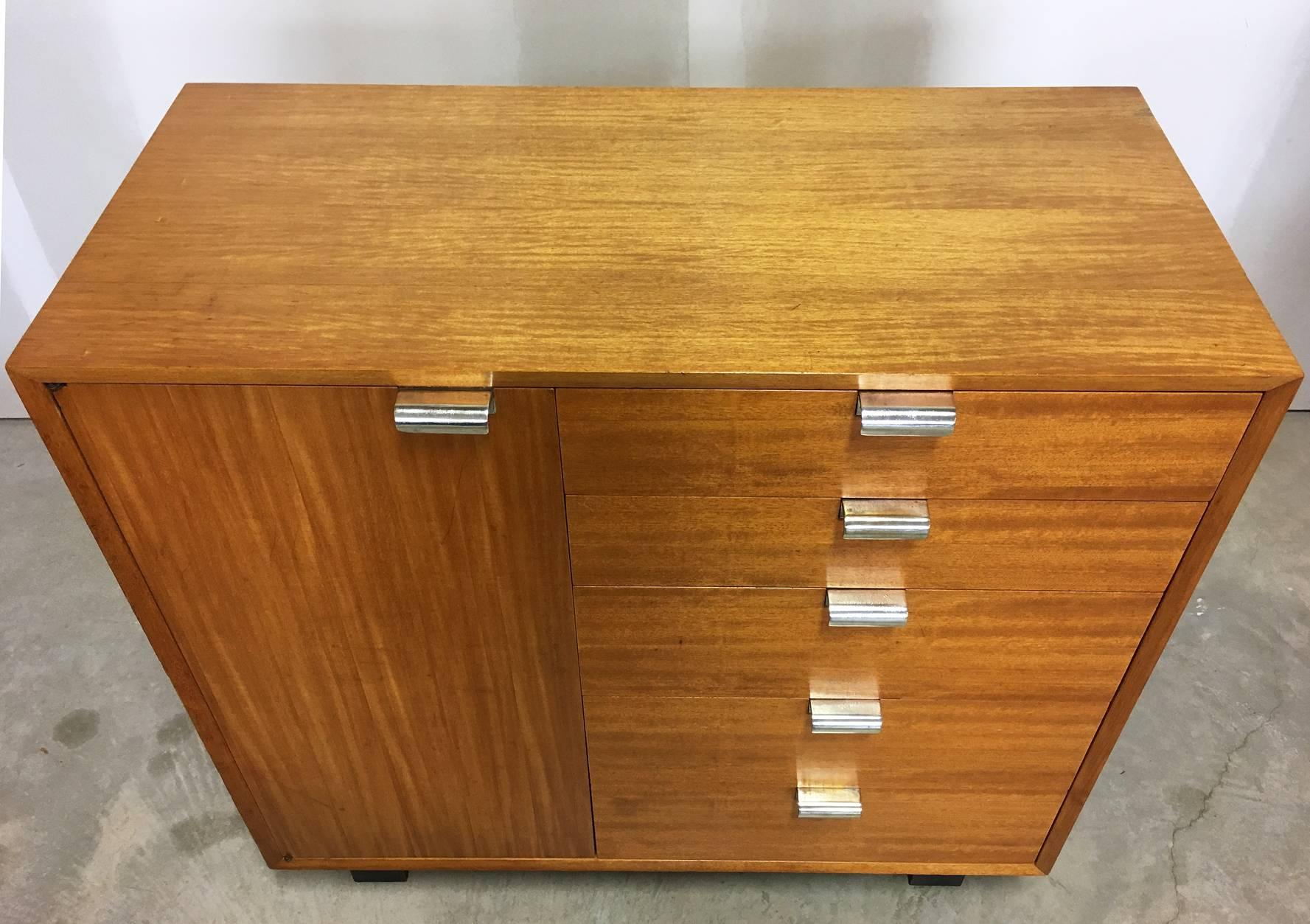 Pair of early George Nelson for Herman Miller Primavera cabinets, Circa late 1940s-early 1950. The cabinet on the left features a door that opens to adjustable shelves for storage, and five drawers, each with recently polished silver pulls. The