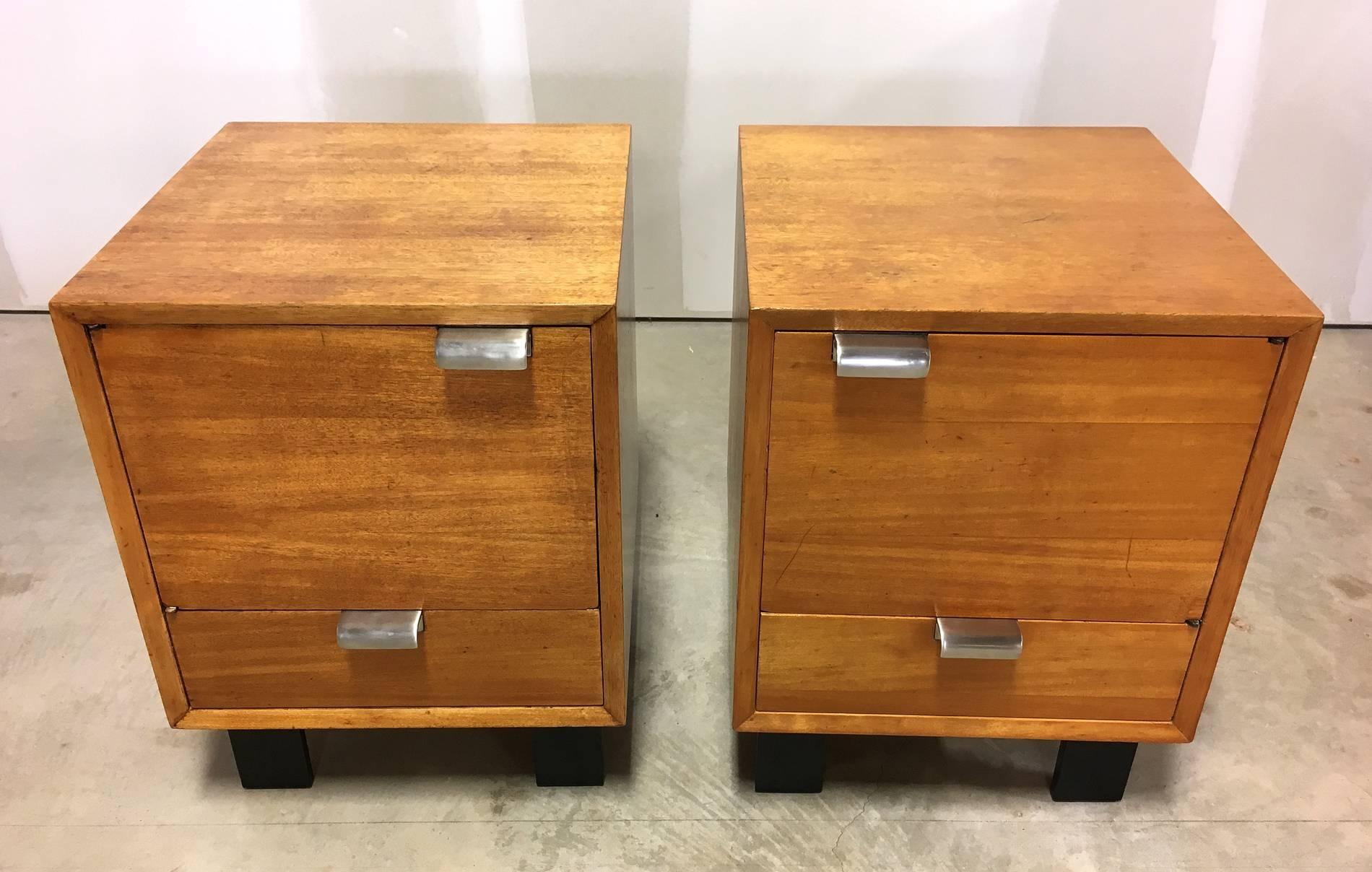 Pair of early George Nelson for Herman Miller Primavera bedside cabinets, #1407. Circa late 1940s-early 1950s. The cabinets each feature a door that opens for storage, with a single drawer below, with Classic Nelson chrome pulls. The base of the