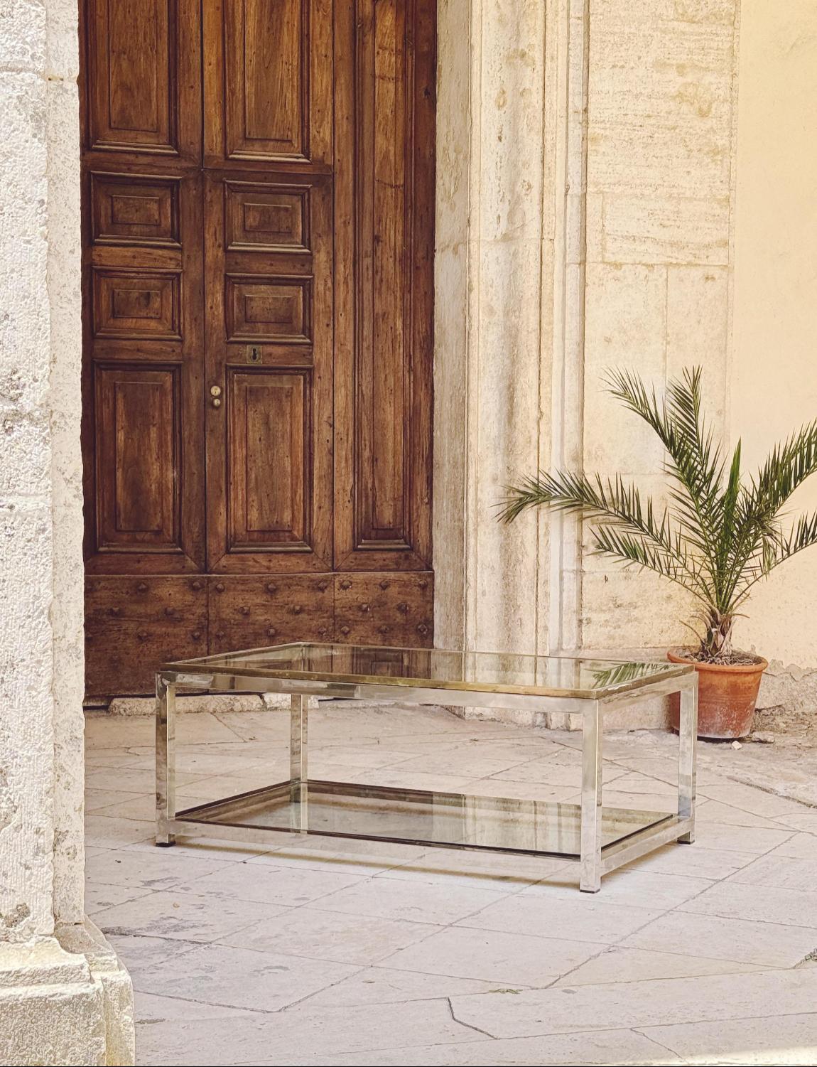 A superb example of a Romeo Rega coffee table. With chrome and brass inlay and a glass shelf both on the top and the bottom, this makes for an exceptional coffee table. This heavy piece of Italian design furniture is in good condition.