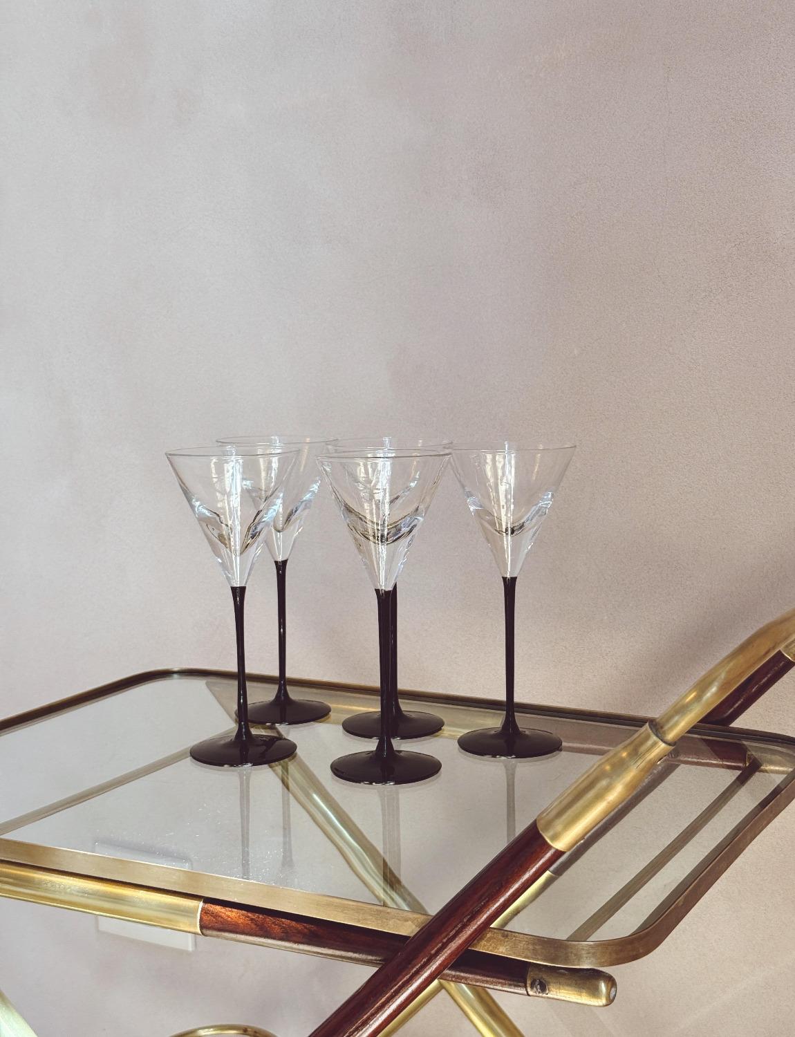 Un ensemble de verres à cocktail soufflés à la main avec de longues tiges noires et des coupes en verre épais pour contenir la quantité parfaite d'alcool. Ces pièces de belle facture sont en bon état et conviendraient parfaitement à tout bar