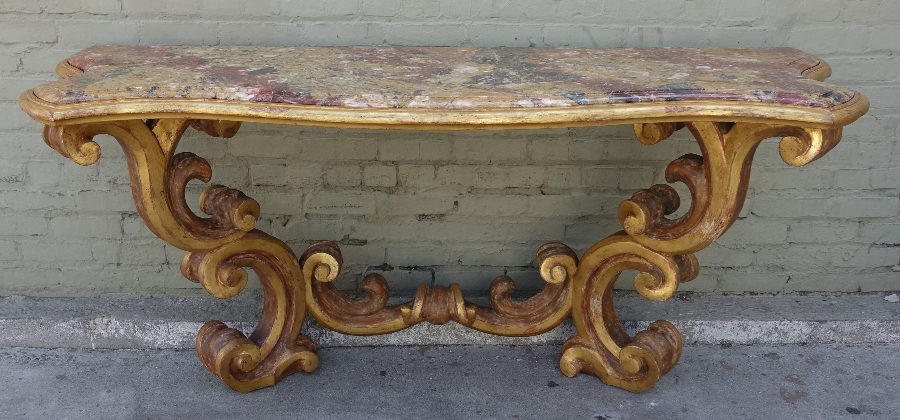 Italian giltwood scrolled carved wood console with serpentine shaped marble top.