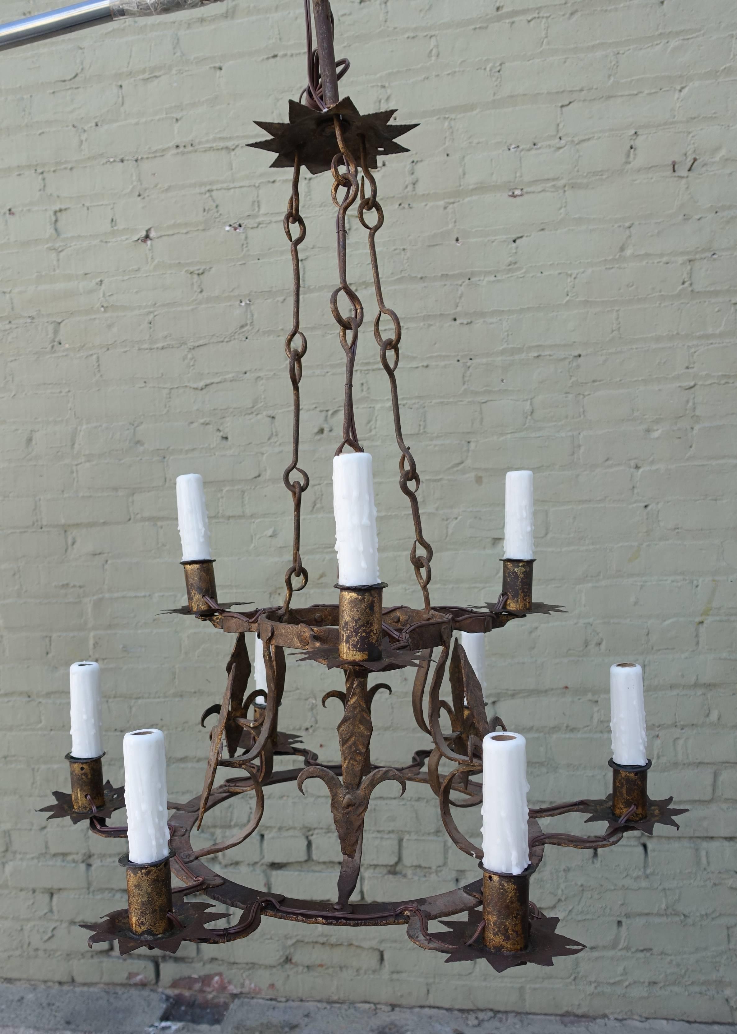 Spanish hand-wrought iron nine-light, two-tiered chandelier incorporating fleur-de-lys throughout. Newly wired with drip wax candle covers. Ready to install.
