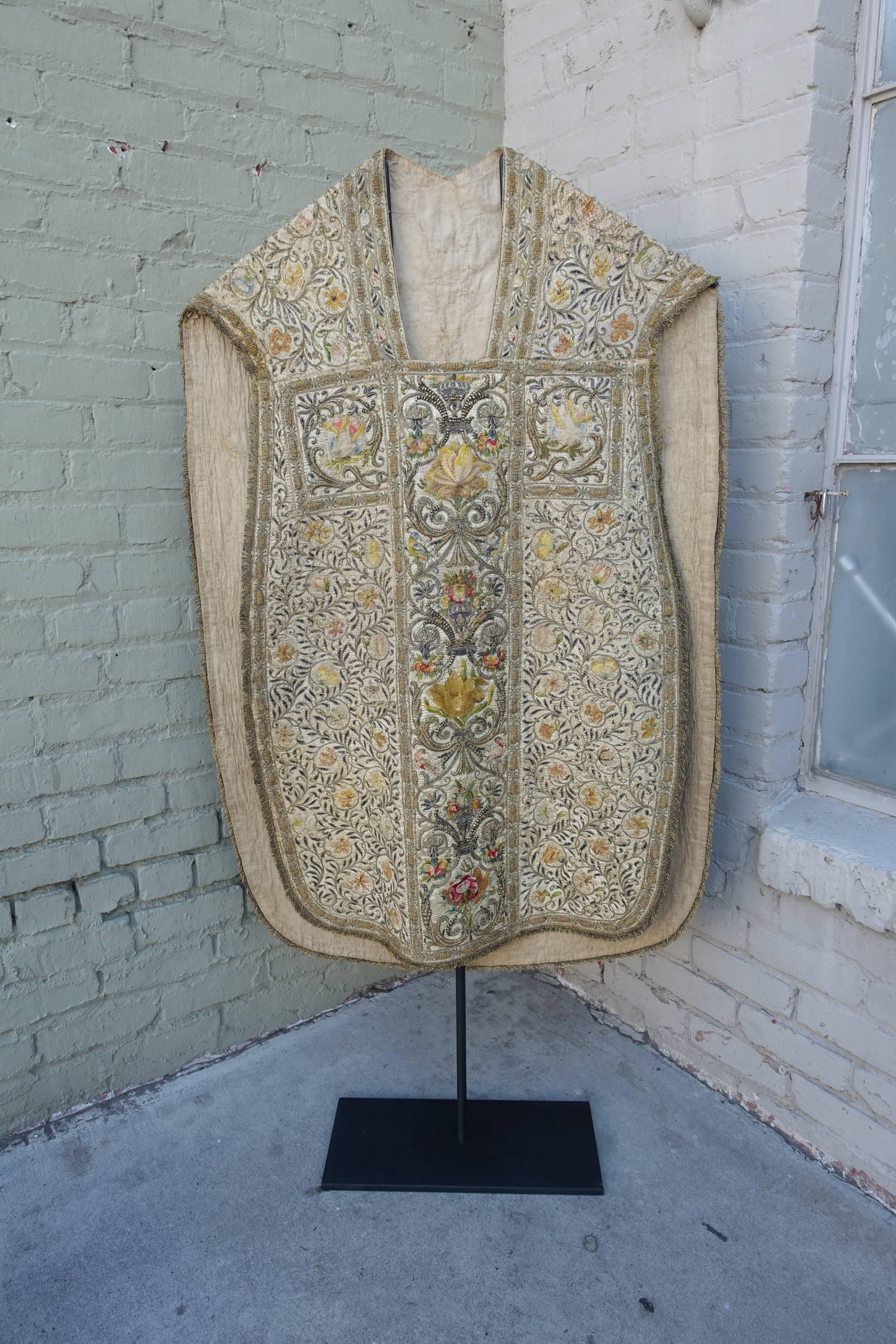 18th century hand metallic and silk embroidered Italian vestment displayed on an iron stand.