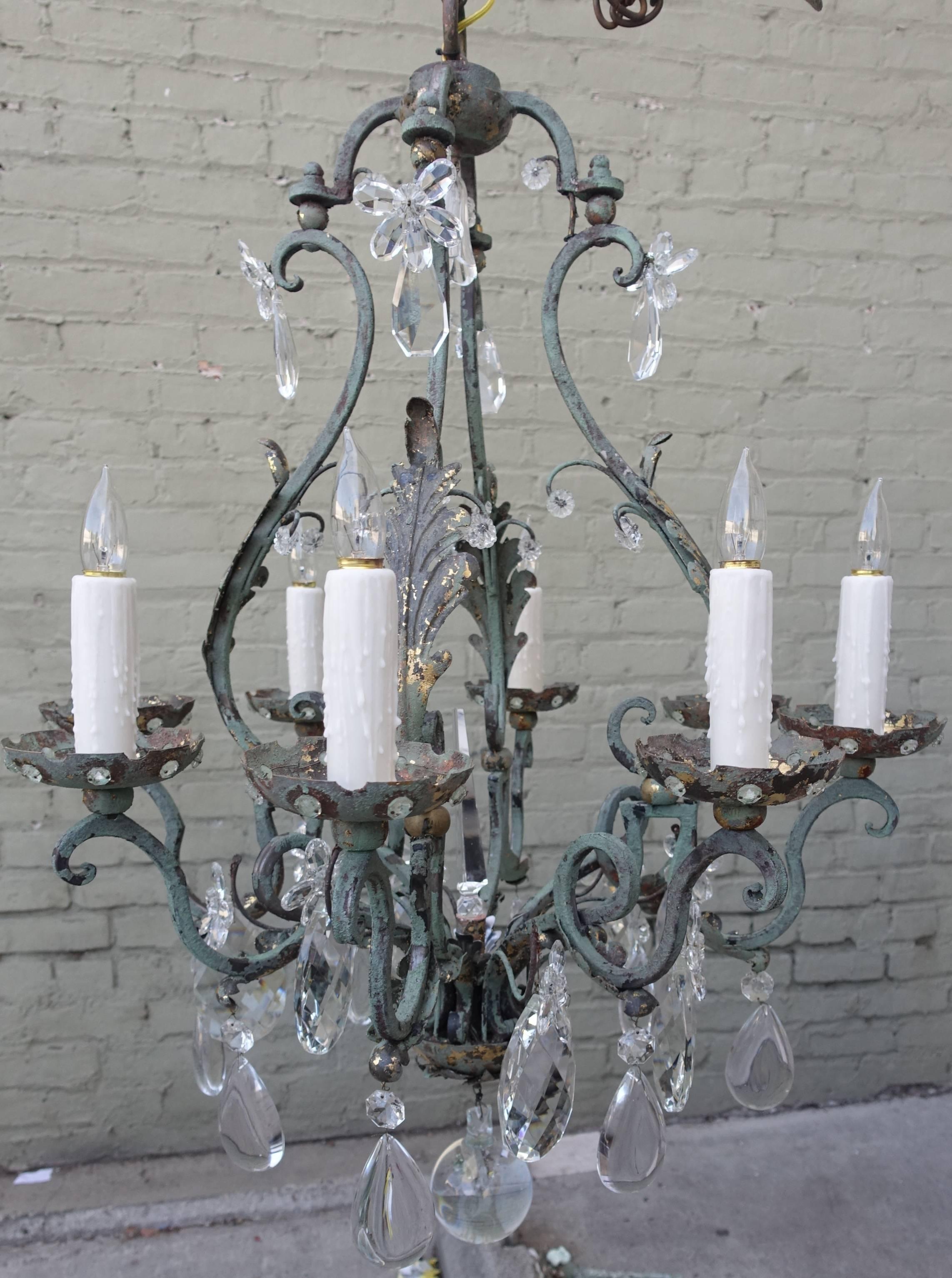 Eight-light French green painted wrought iron chandelier adorned with beautiful crystals throughout. Newly rewired with drip wax candle covers. Chain and canopy included.